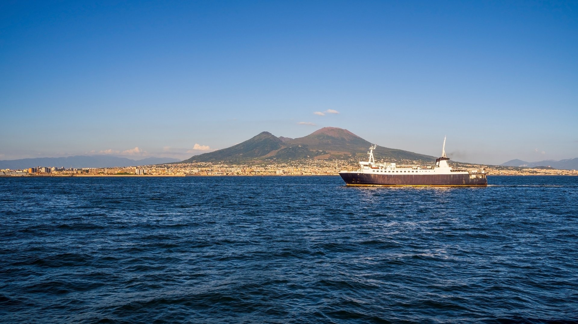 Ferry Crossing the Sea with Mount Vesuvius in the Background Under a Clear Summer Sky.