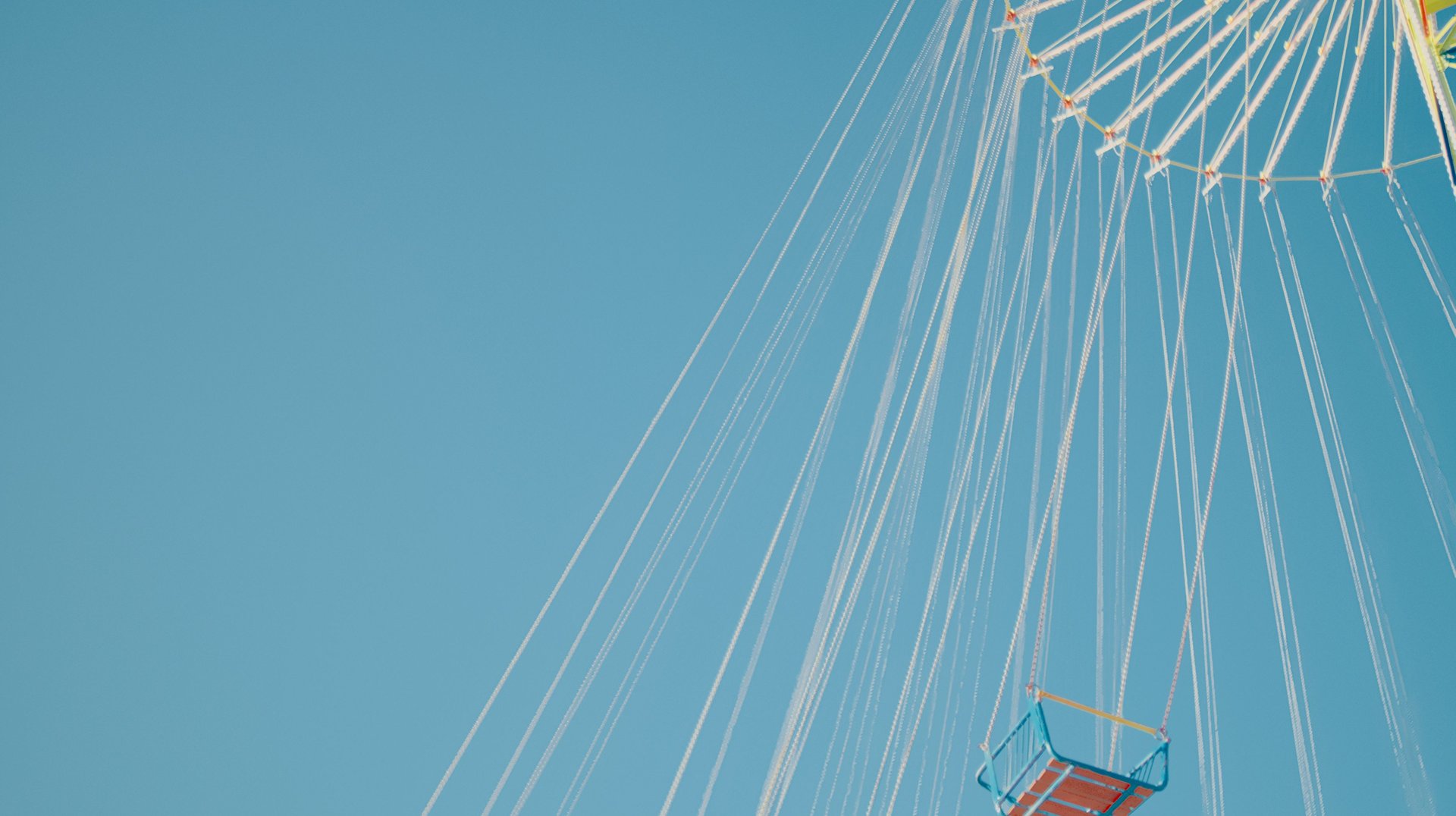 a Vibrant Swing Carousel Ride Set Against a Clear Blue Sky, Capturing Summer Fun.