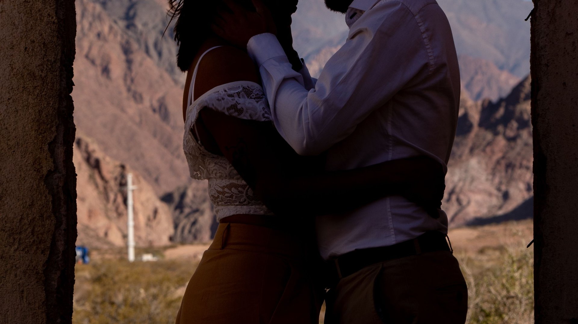 Romantic Silhouette of Couple Embracing in a Doorway with Mendoza's Scenic Mountain Backdrop.