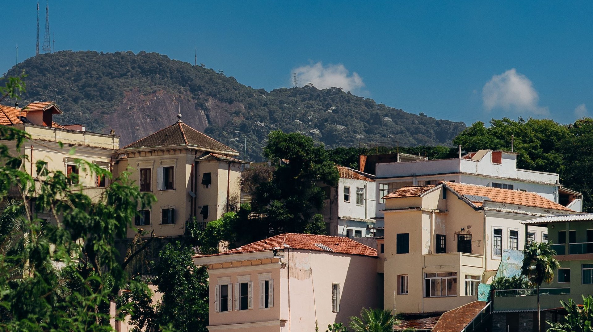 Charming Colorful Houses in Santa Teresa Neighborhood, Rio De Janeiro, with Lush Greenery and Blue Sky.