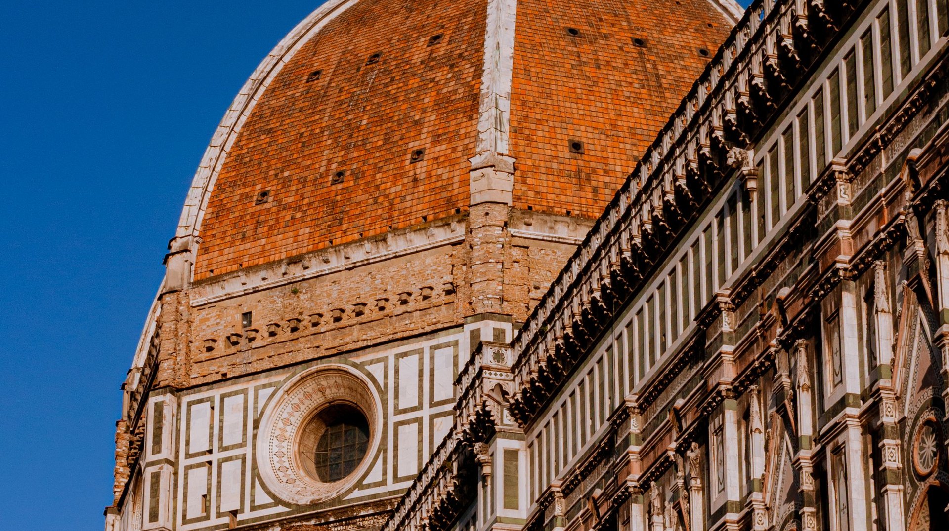 Elegant View of Florence's Iconic Duomo Brunelleschi Dome Under Blue Sky, Highlighting Renaissance Architecture.