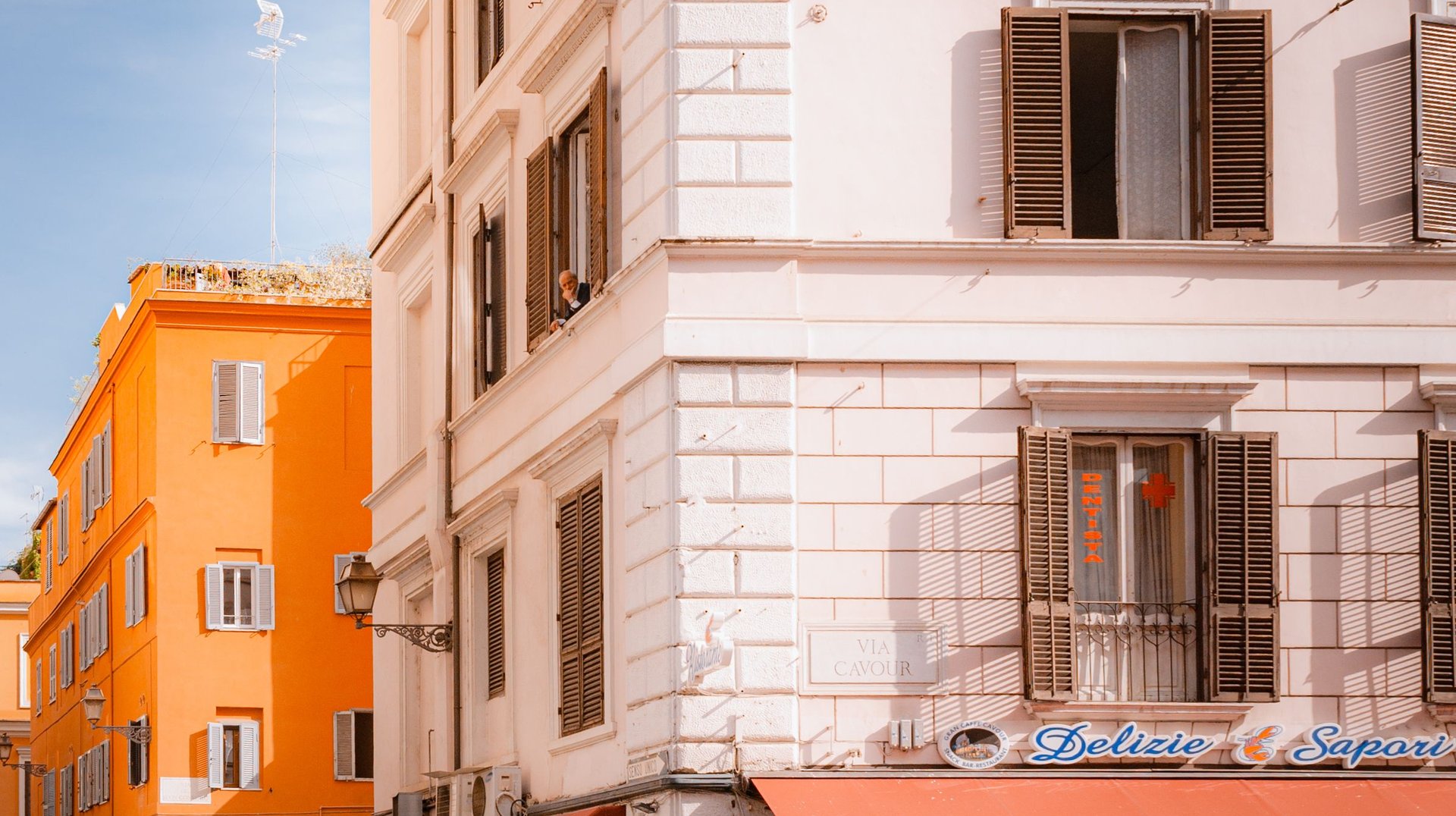 Bustling Street Corner in Rome's Trastevere with Vibrant Buildings and Pedestrians.