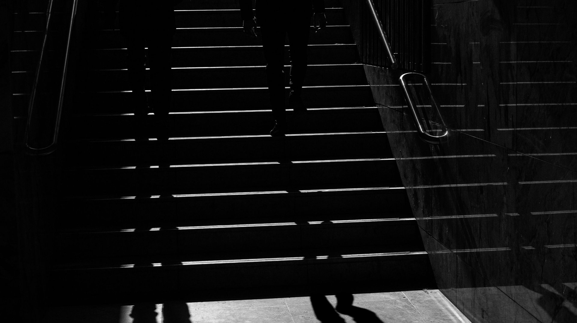 Dramatic Black and White Photo of Silhouetted People on a City Staircase in Lisbon.