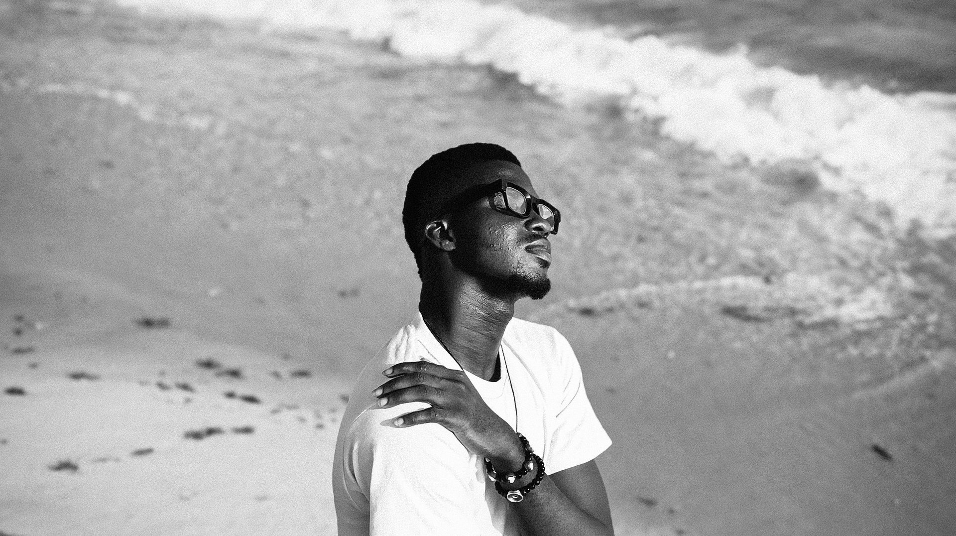 Black and White Photo of a Young Man Enjoying a Tranquil Beach in Lagos, Nigeria.
