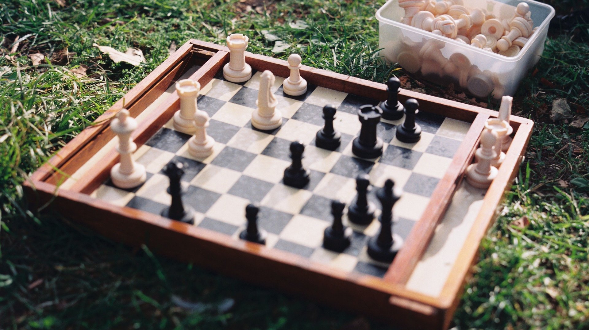 Strategic Chess Game Set Up on Grass in Lisbon Park, Capturing a Moment of Outdoor Relaxation.