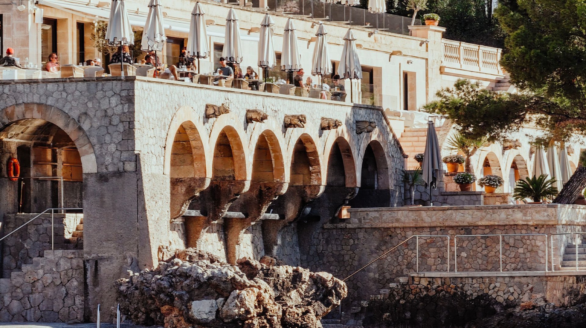 Charming Coastal Hotel with Elegant Arches Overlooking the Mediterranean Sea, Offering a Scenic Vacation Spot.