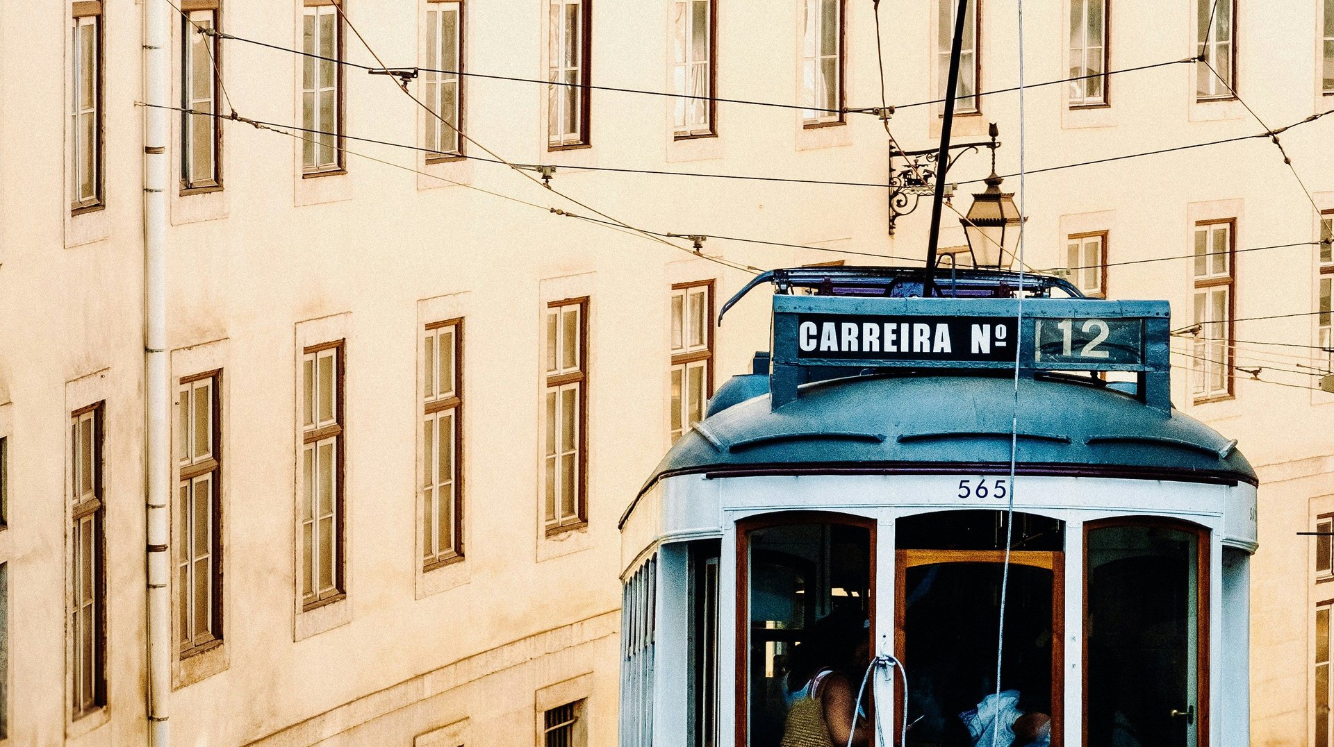 Charming Lisbon Tram Winds Through Historic Architecture, Symbolizing Classic City Transport.