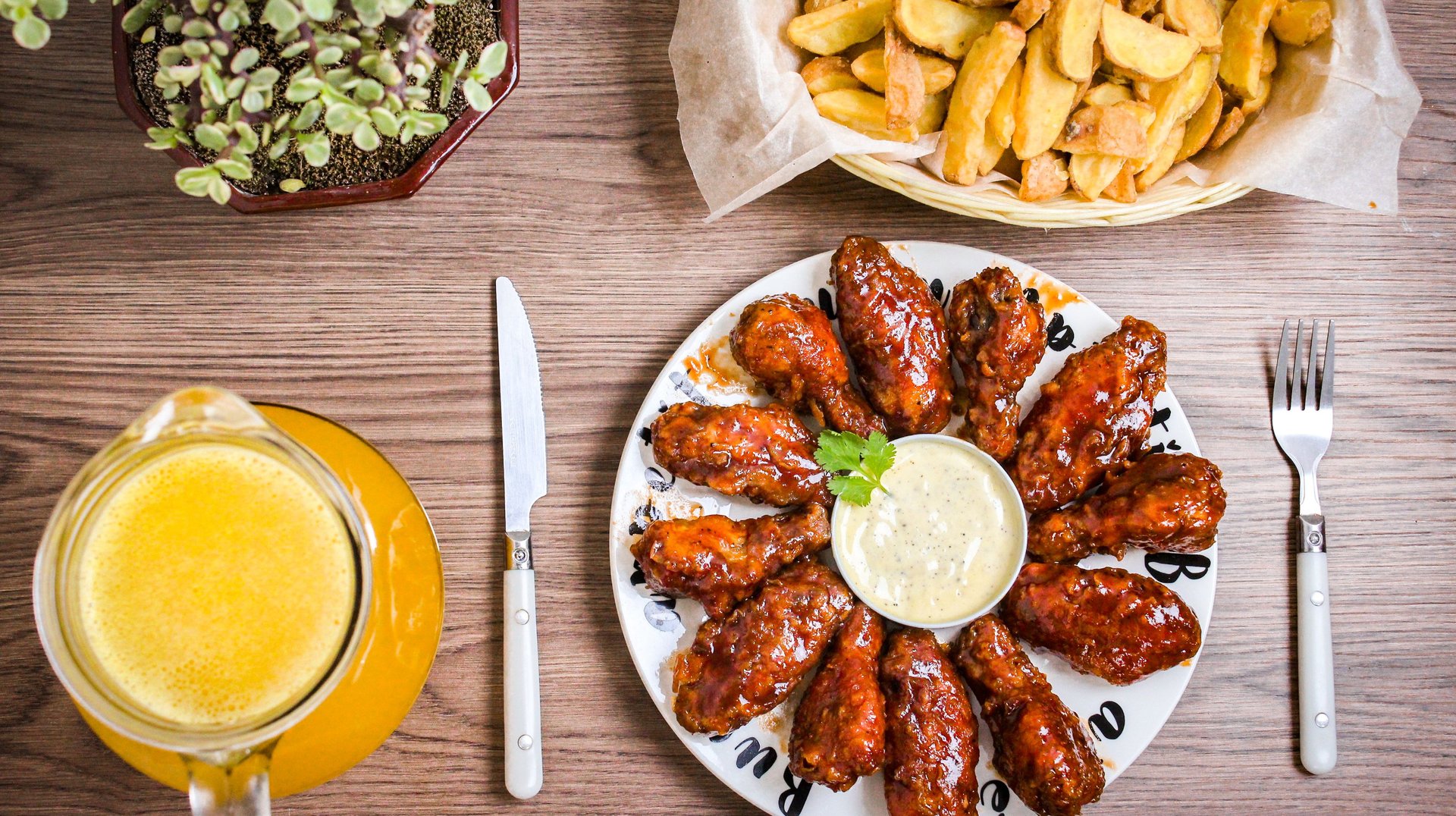 Mouthwatering Glazed Chicken Wings Paired with Crisp Fries and a Refreshing Beverage. Perfect for a Tasty Meal.