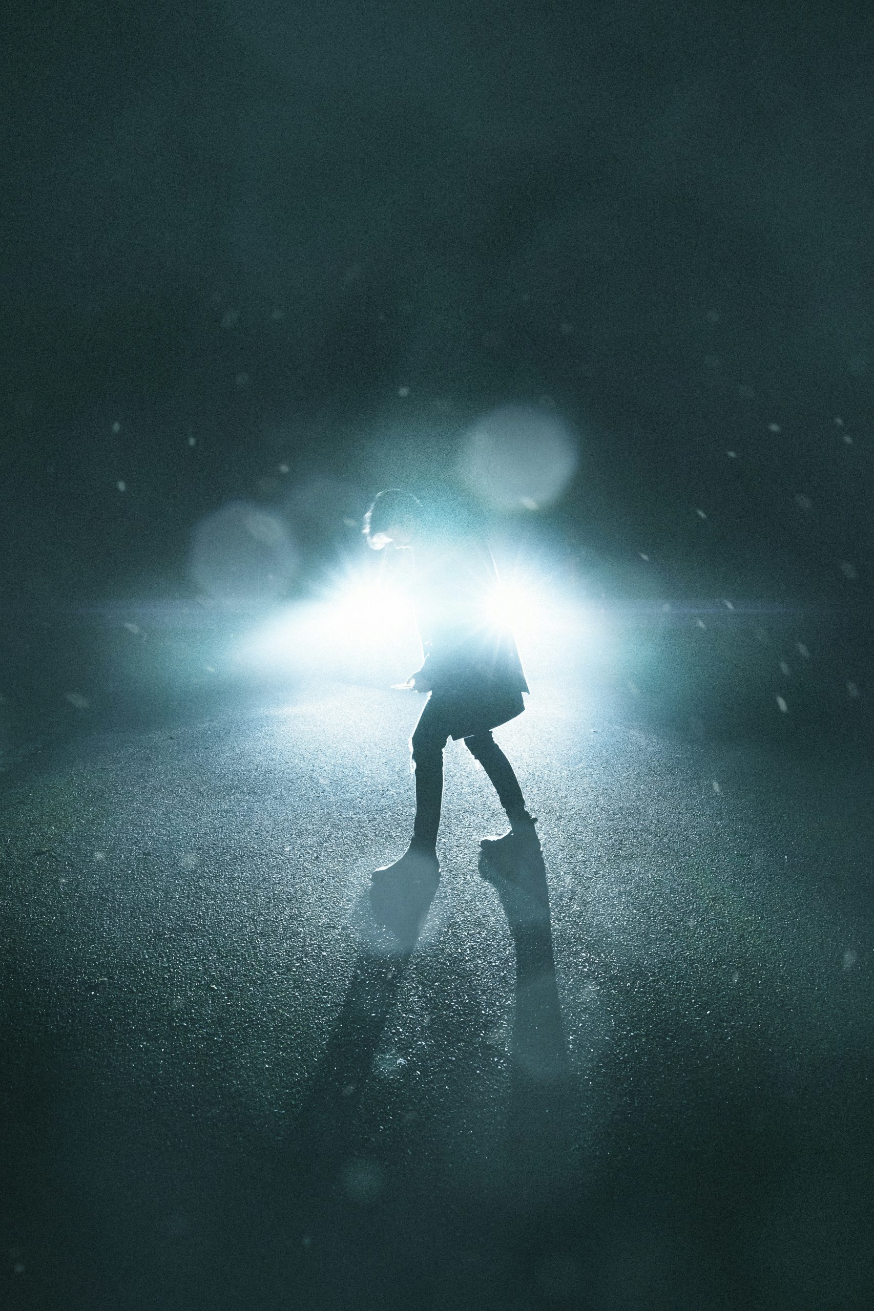 Silhouette of man standing under blue and white light