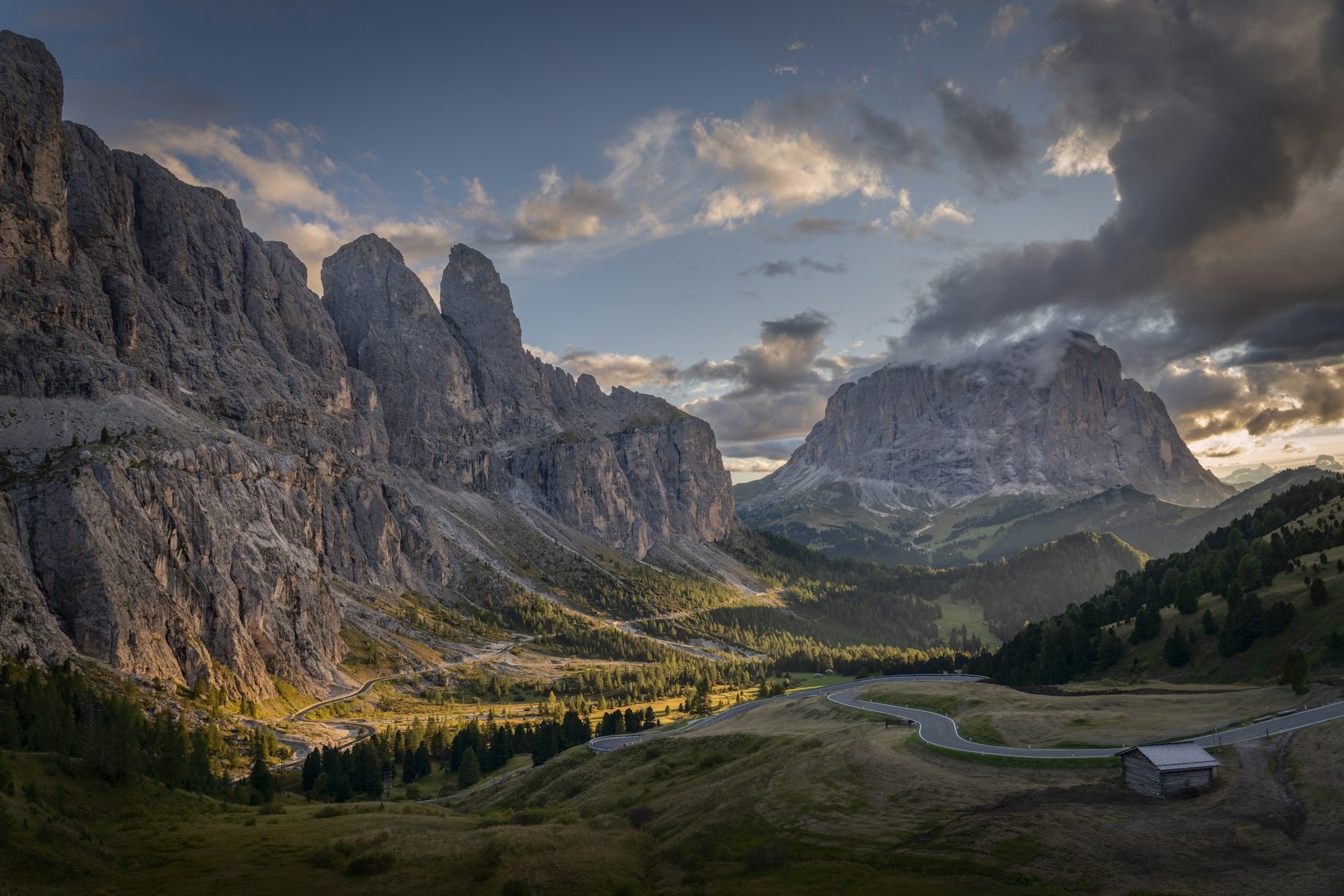 Dramatic Mountain Valley With A Winding Road And Cabin