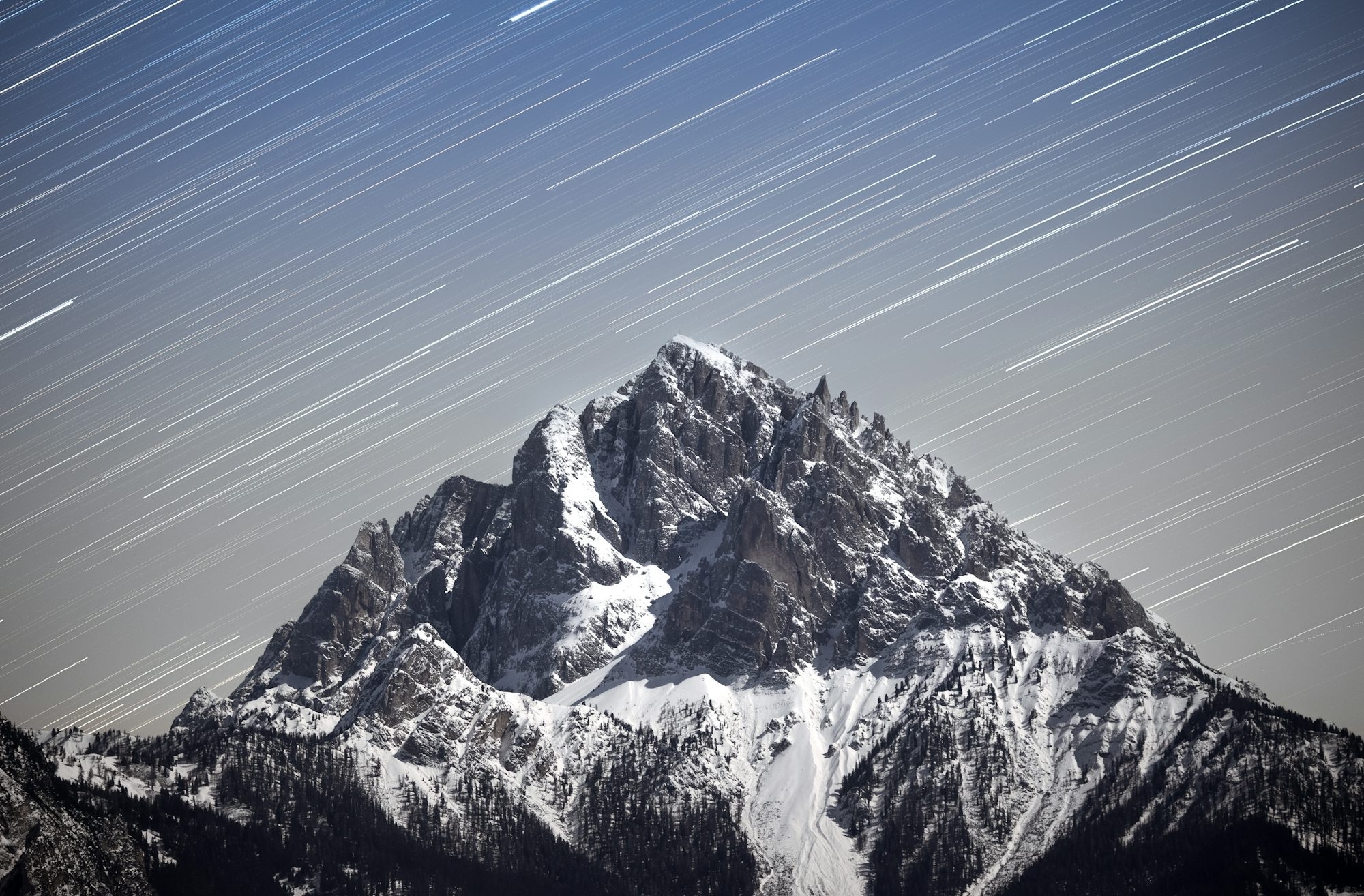 Snowy Mountain Peak Under Streaking Stars