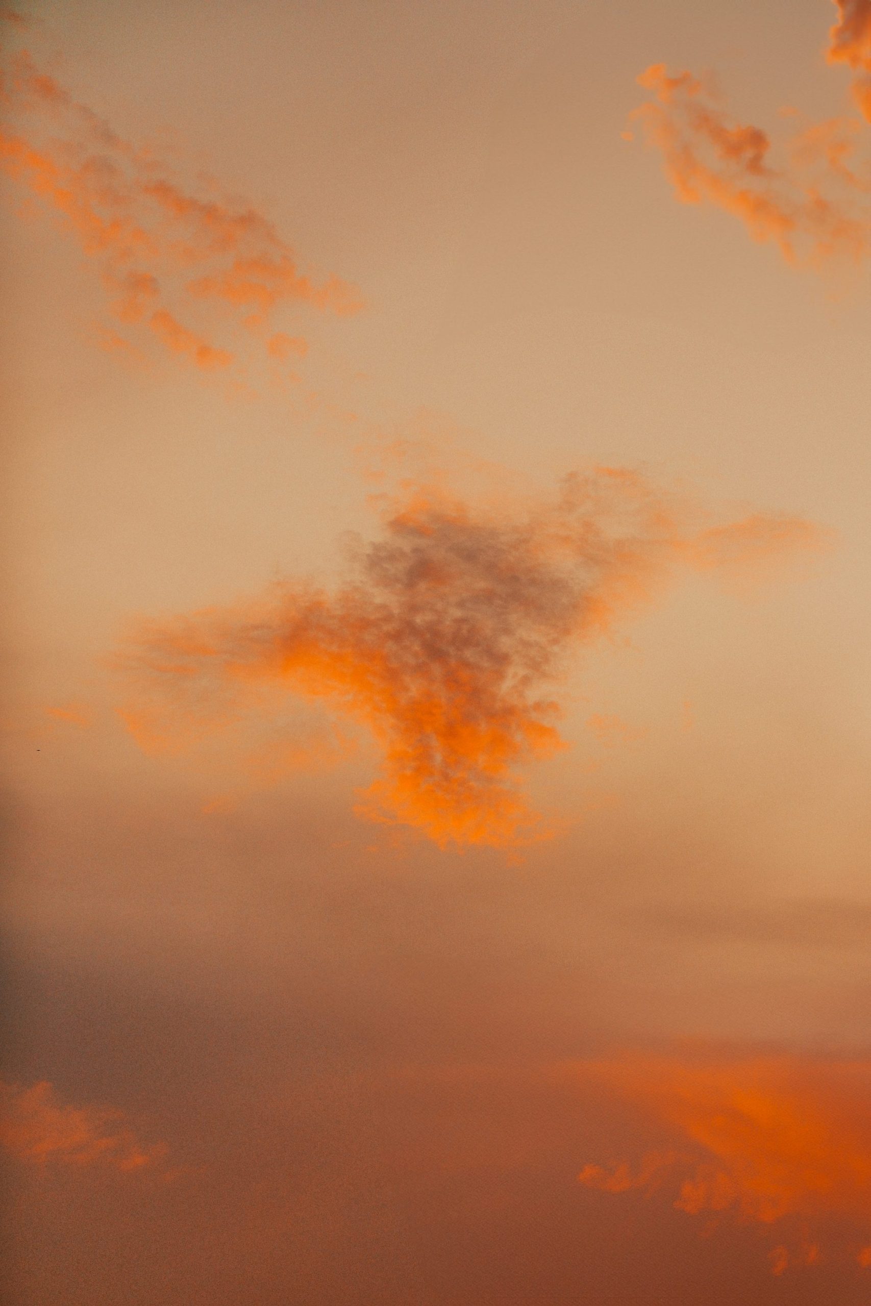Orange Clouds Drift In A Soft, Hazy Sky