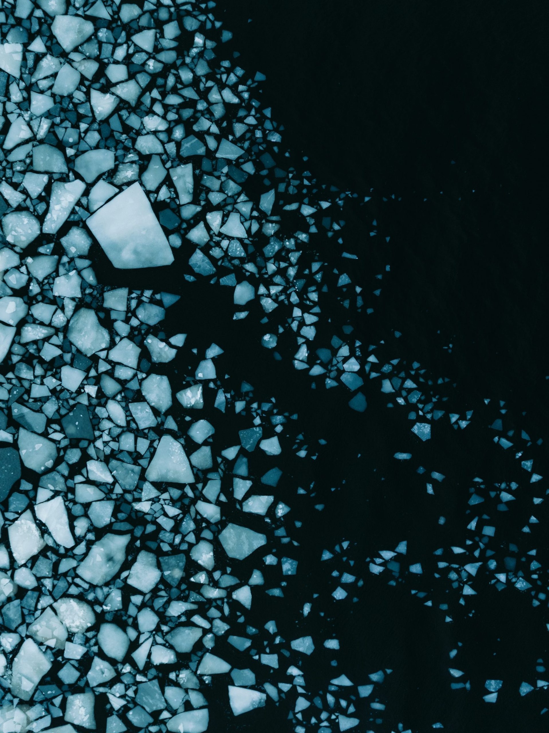 Cracked Ice Pieces Floating On Dark Water Surface