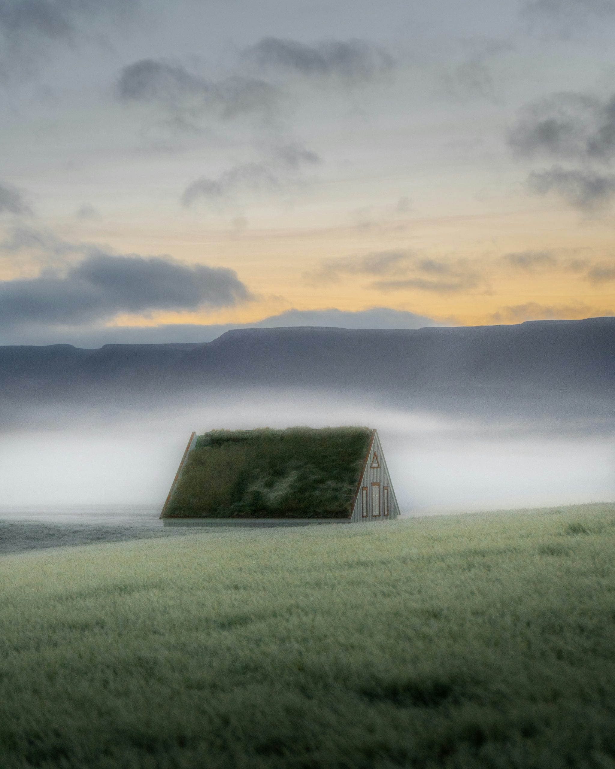 A small house with a grass roof in misty landscape