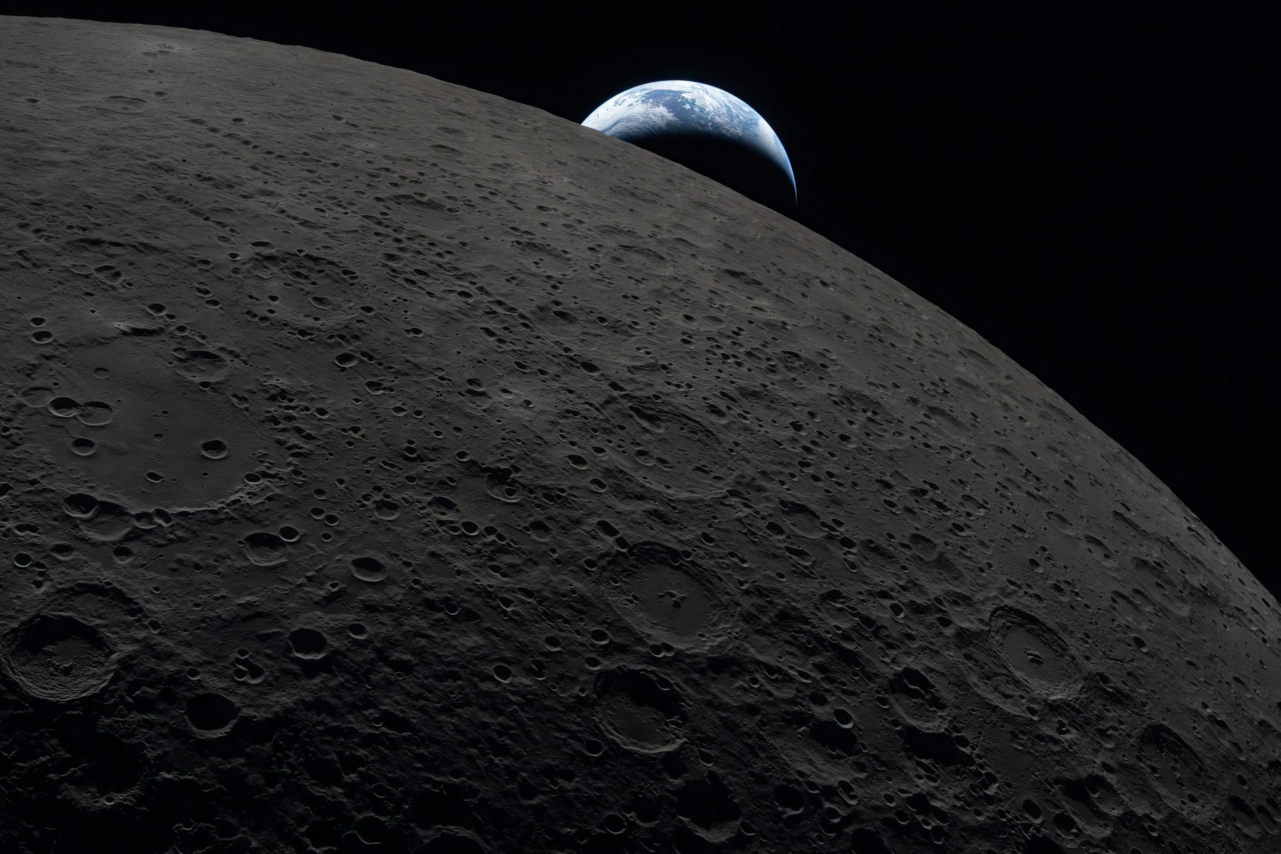 Earth rises over the dark lunar surface