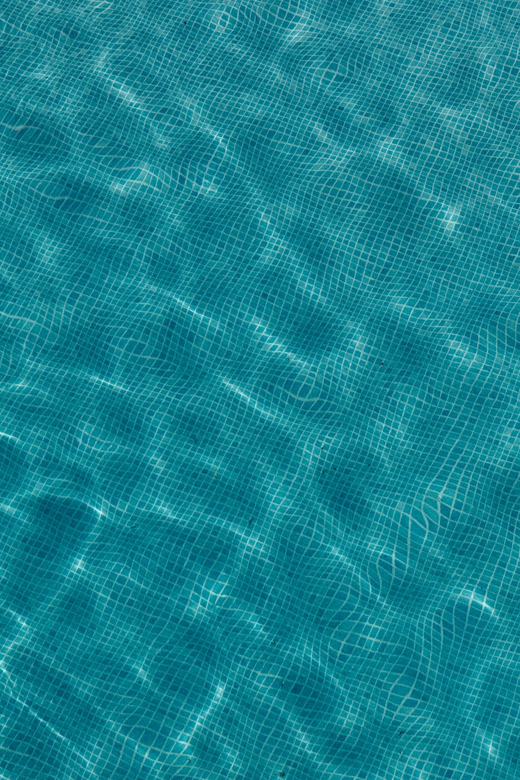 Rippling blue water surface with tiled pattern below