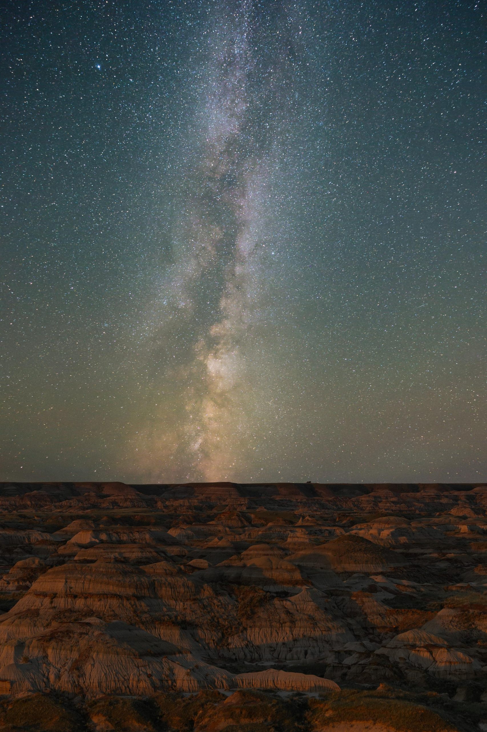 Milky way galaxy over rugged desert landscape at night