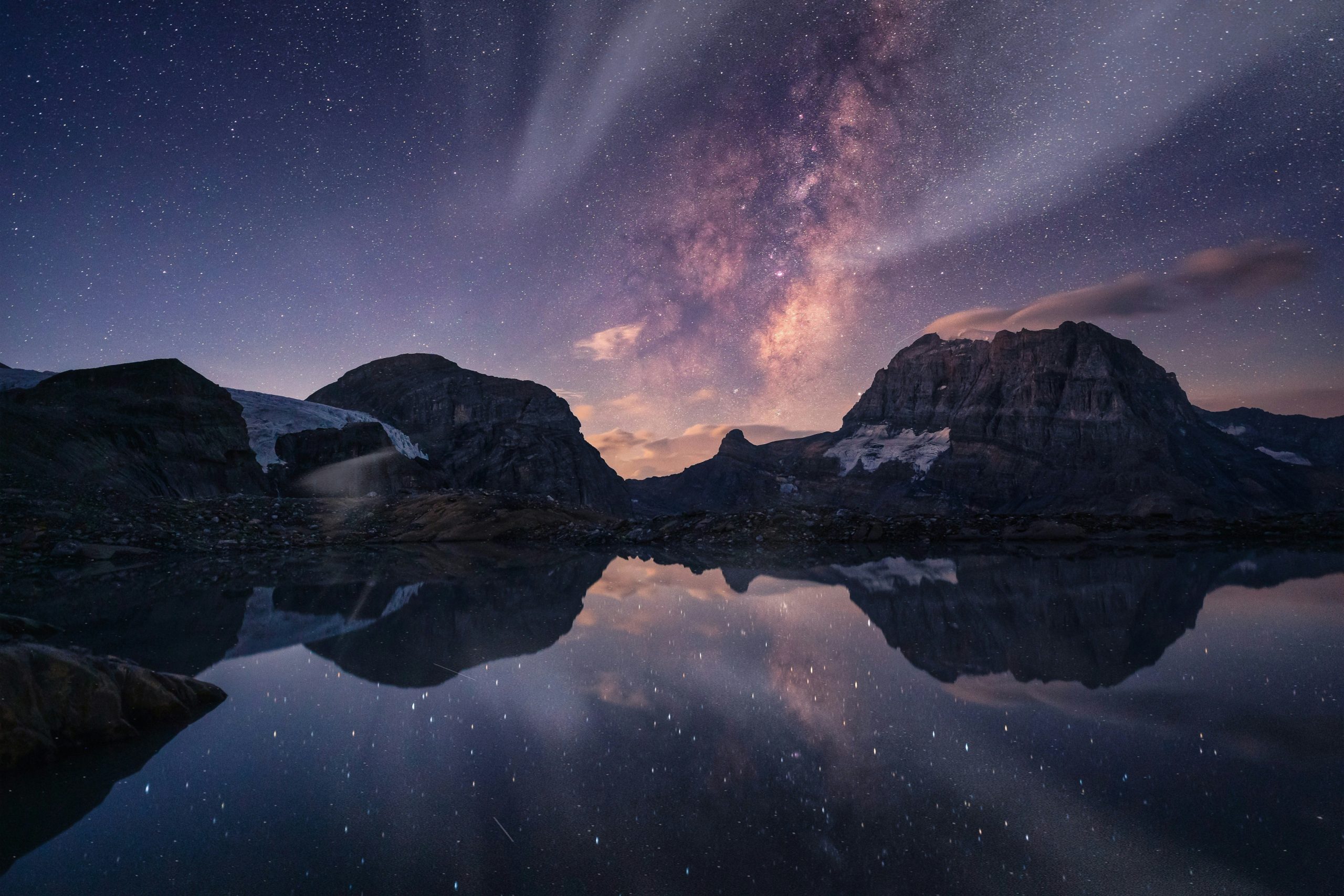 Milky way and mountains reflected in a serene lake