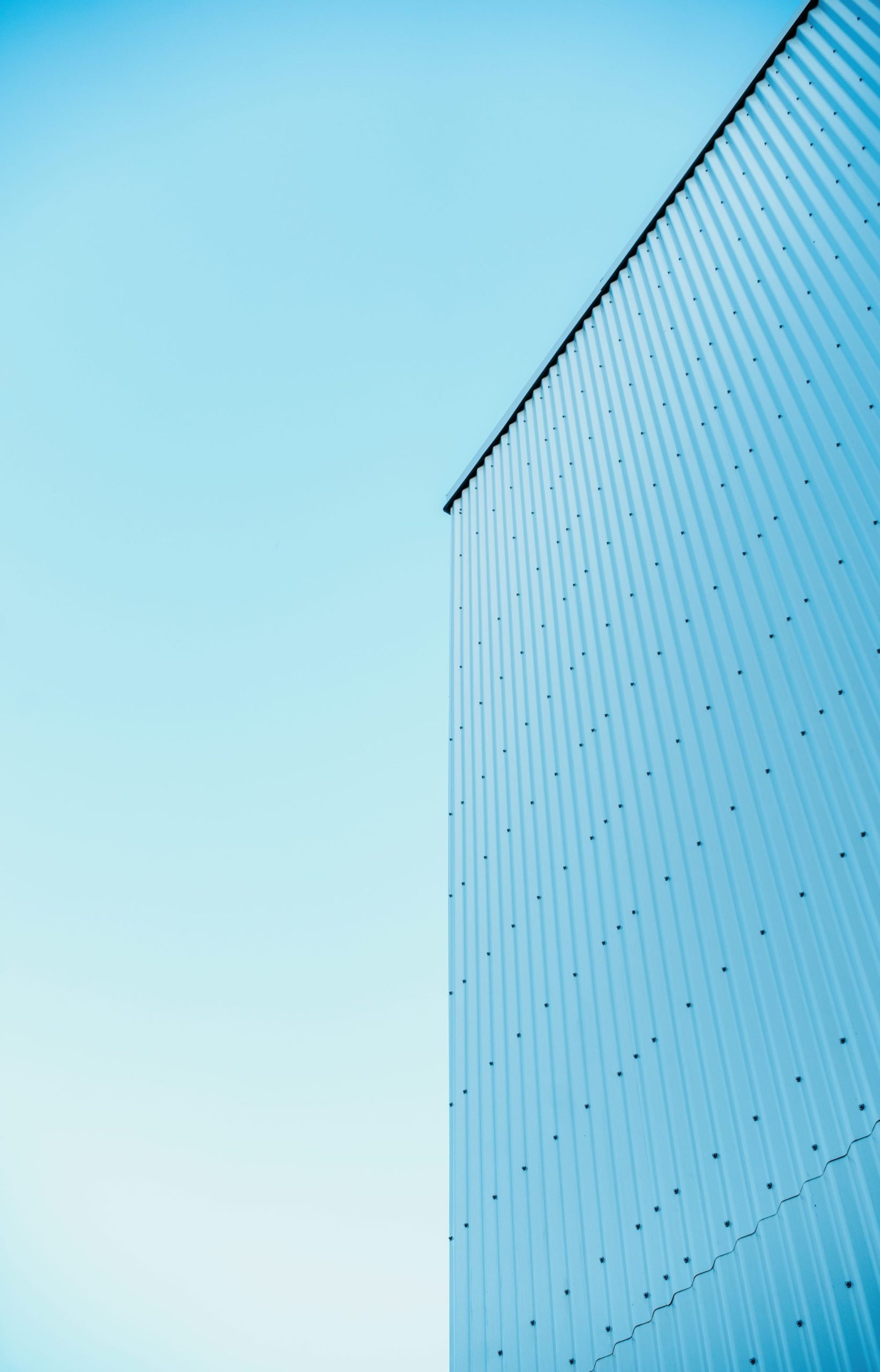 Light Blue Corrugated Metal Wall Against Clear Sky