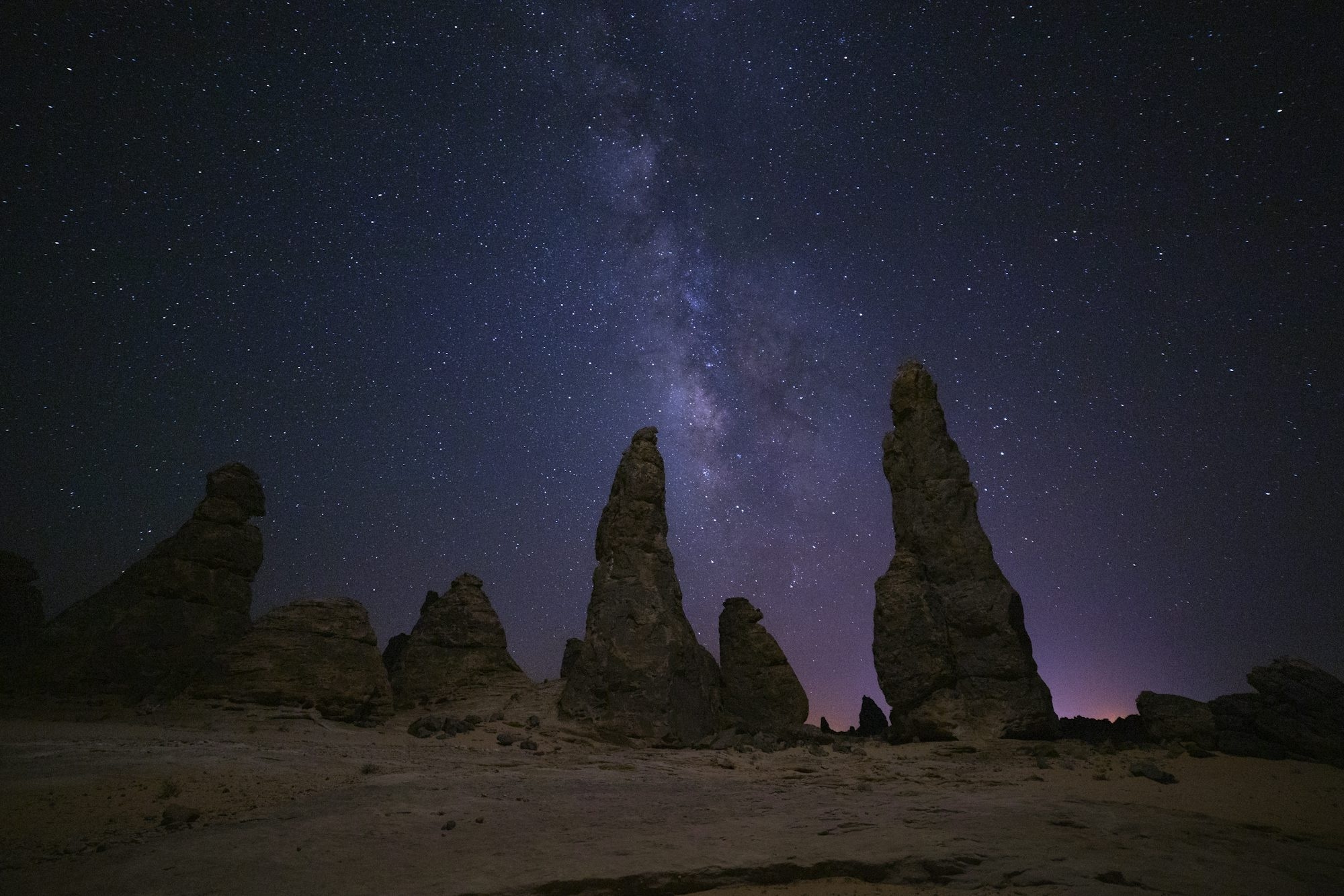 Milky Way Galaxy Shines Above Desert Rock Formations At Night