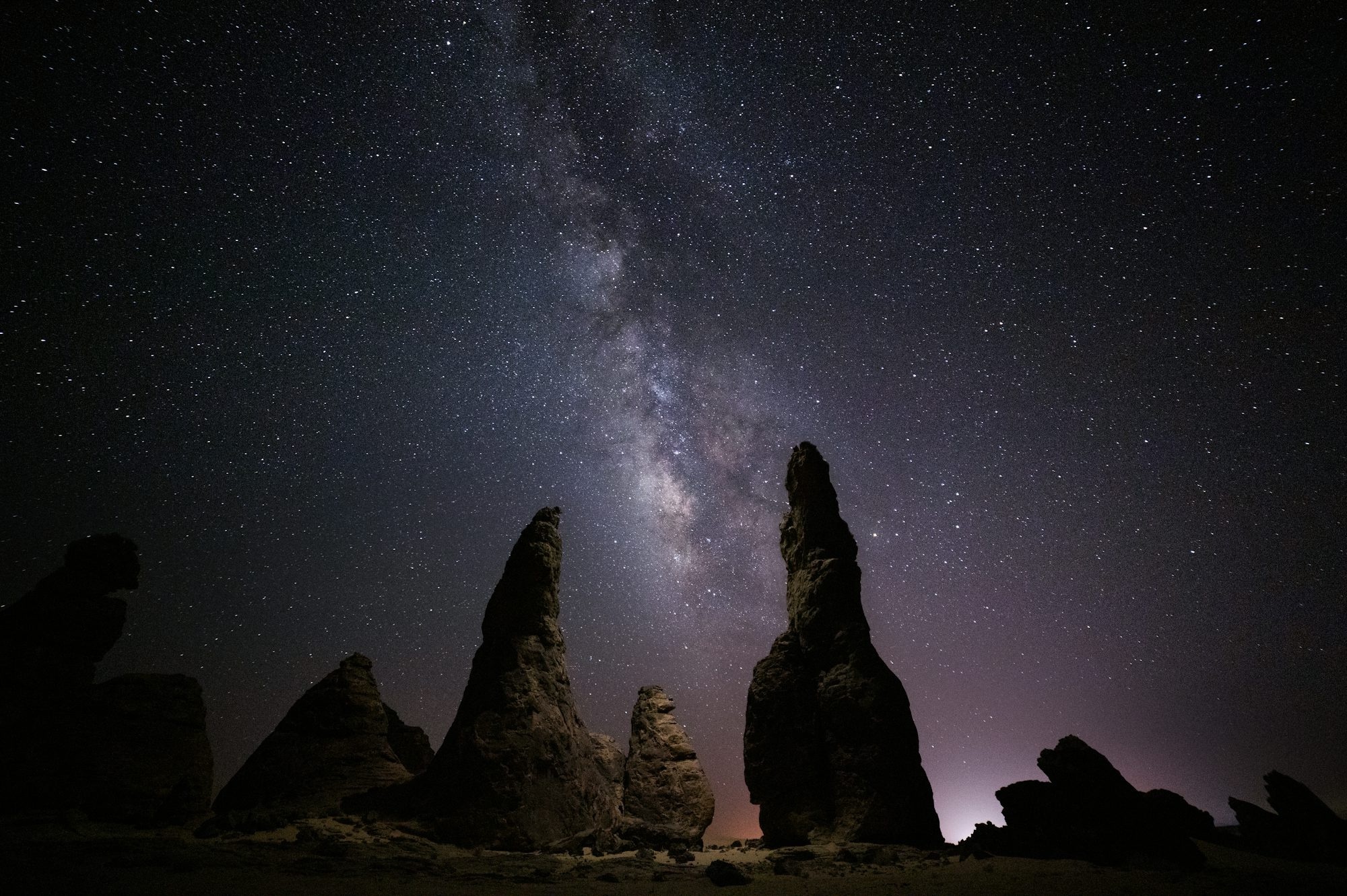 Milky Way Galaxy Shines Above Towering Rock Formations At Night