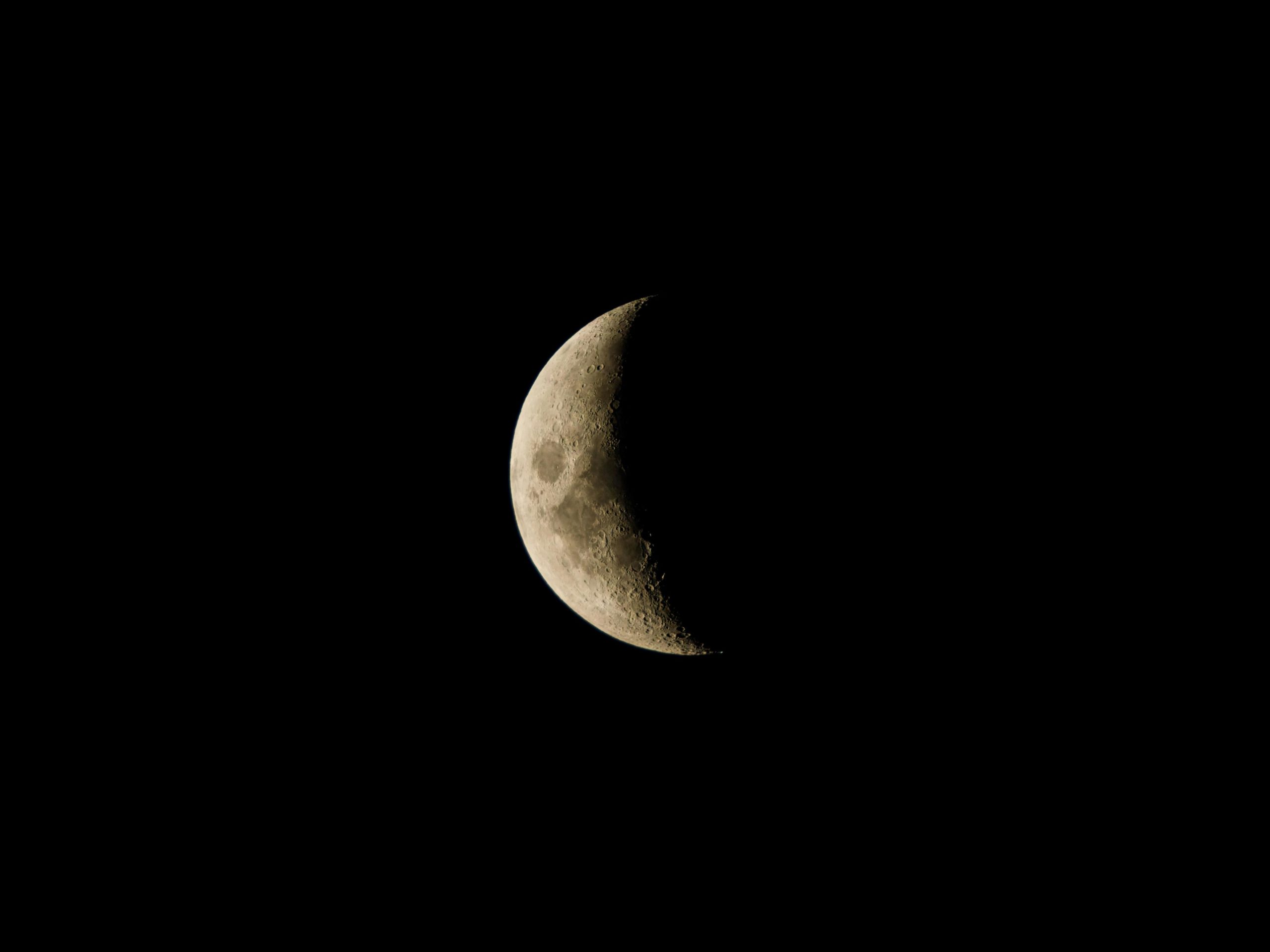 Crescent moon glowing in the dark night sky