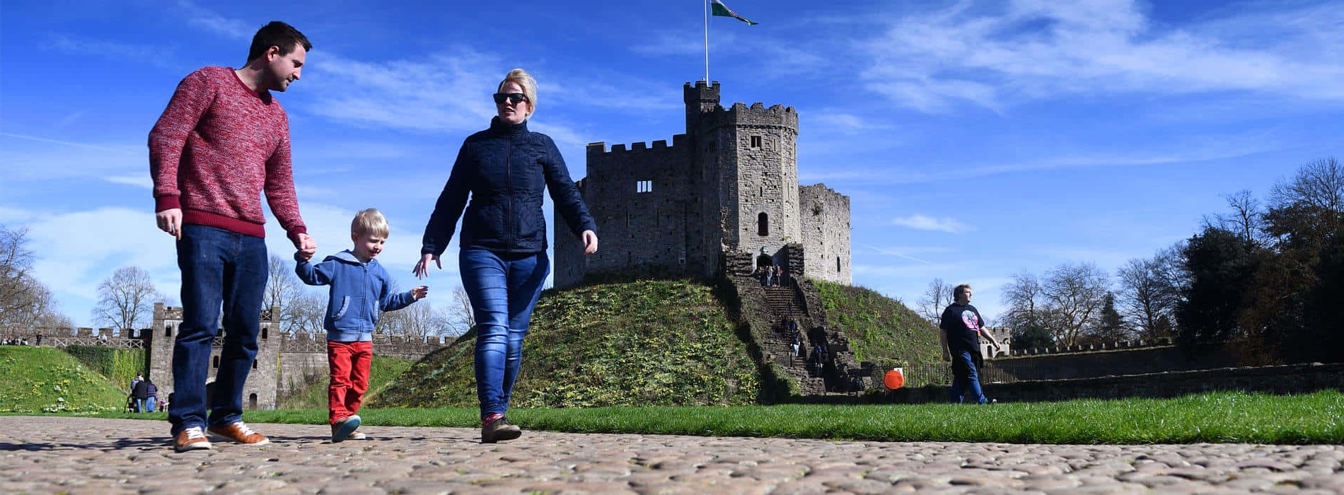 A family walks toward a castle on a sunny day. – Ultra HD Wallpaper