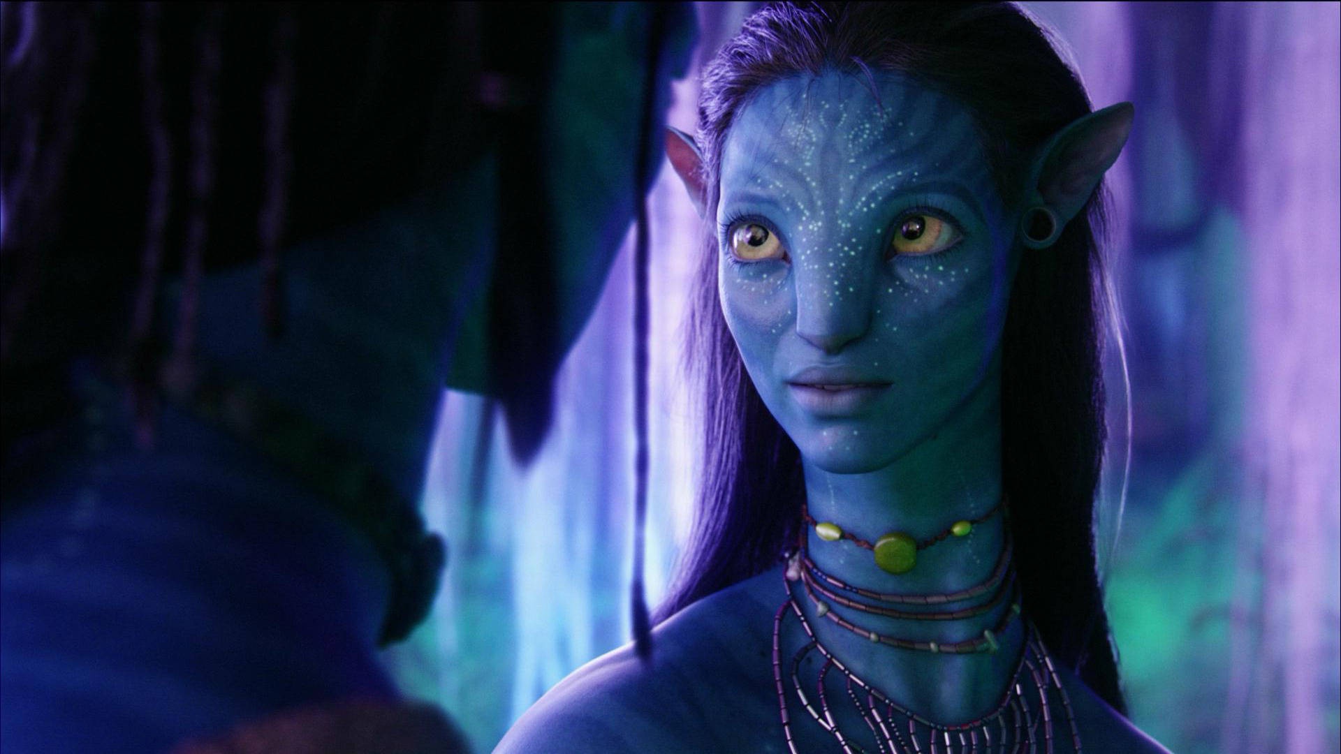 Blue-skinned Na'vi woman with amber eyes in a glowing forest. – Ultra HD Wallpaper