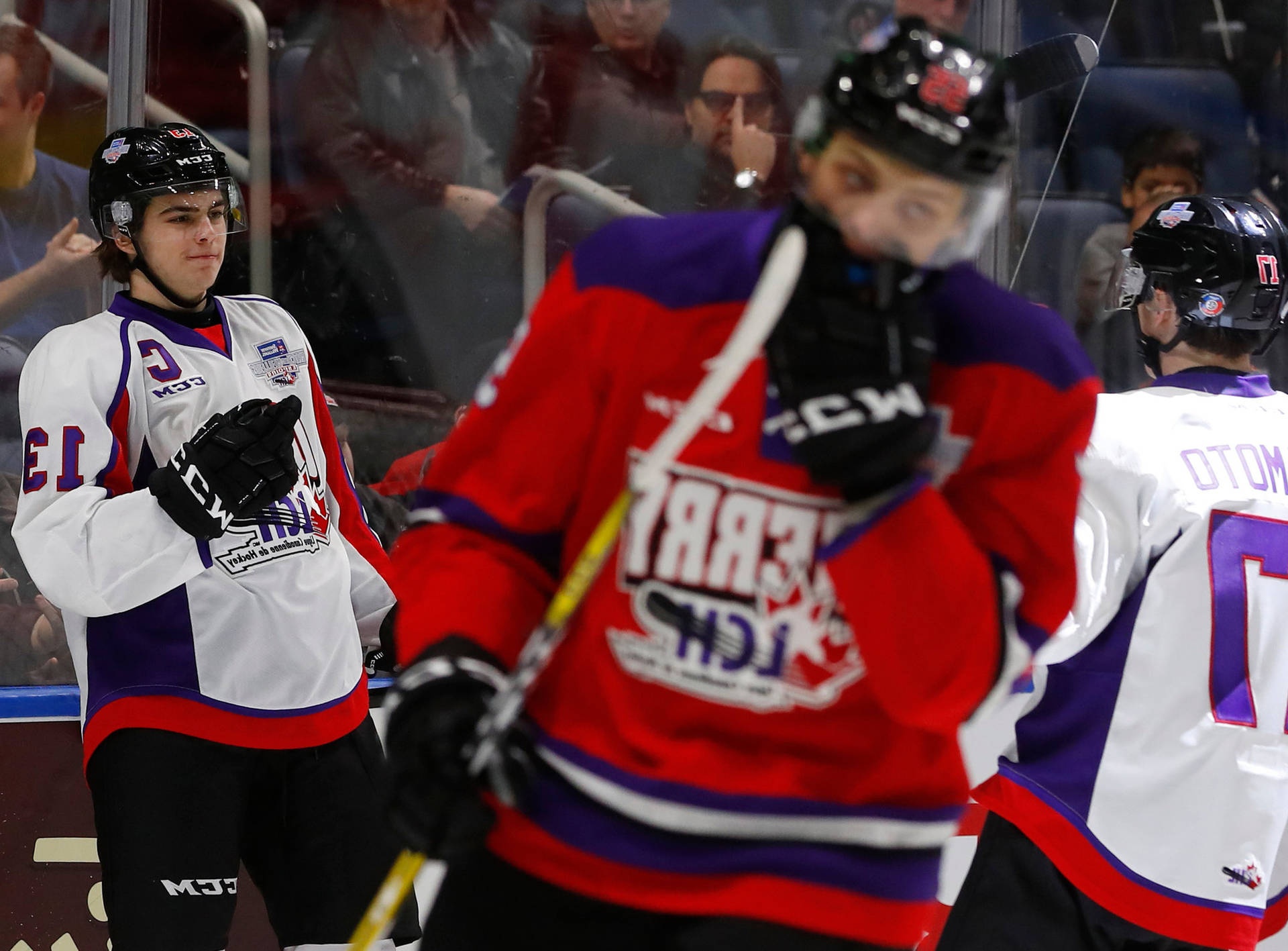Hockey players in red white and purple jerseys on ice during game with spectators behind glass. – Ultra HD Wallpaper