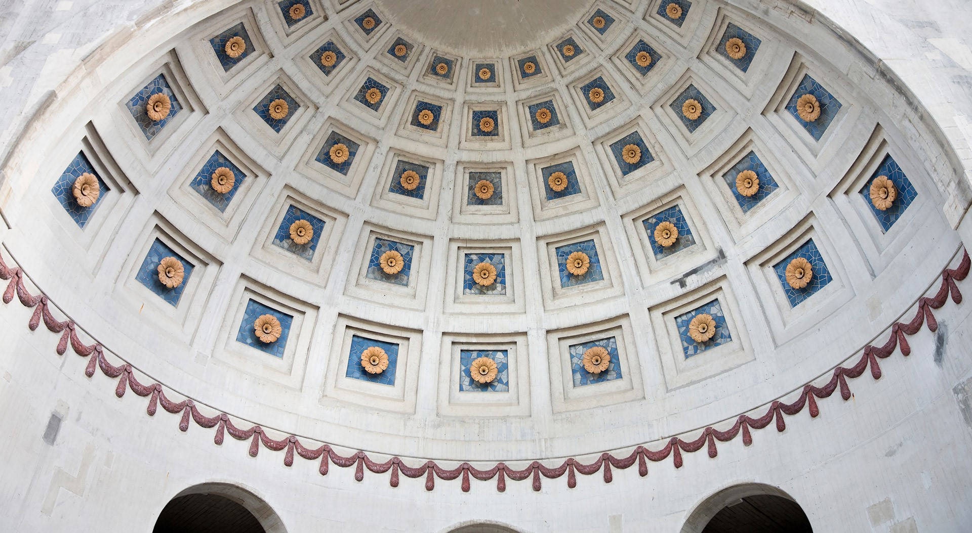 Grand domed ceiling with blue and gold floral medallions and red drapery.