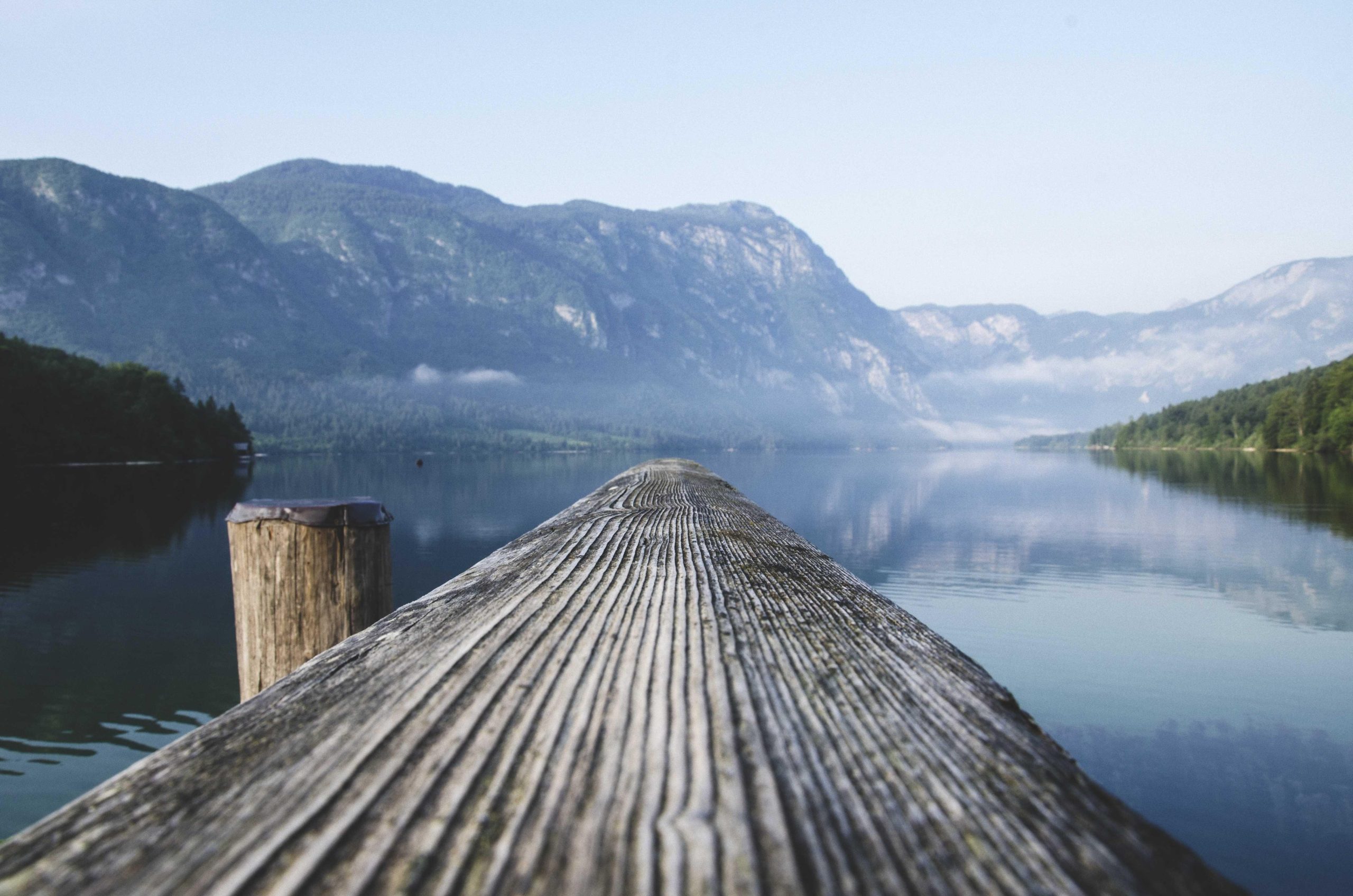 Misty blue morning fog rolling over a quiet coastal landscape