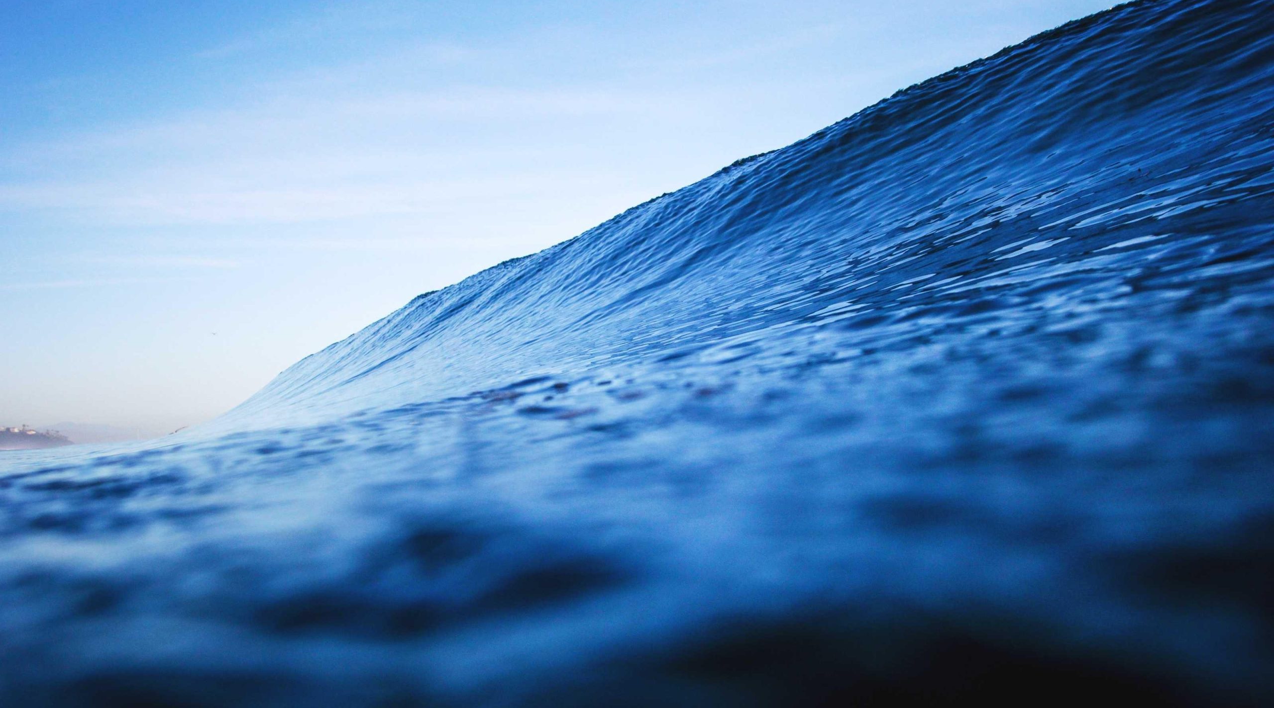 Deep blue ocean waves crashing against rocky shores