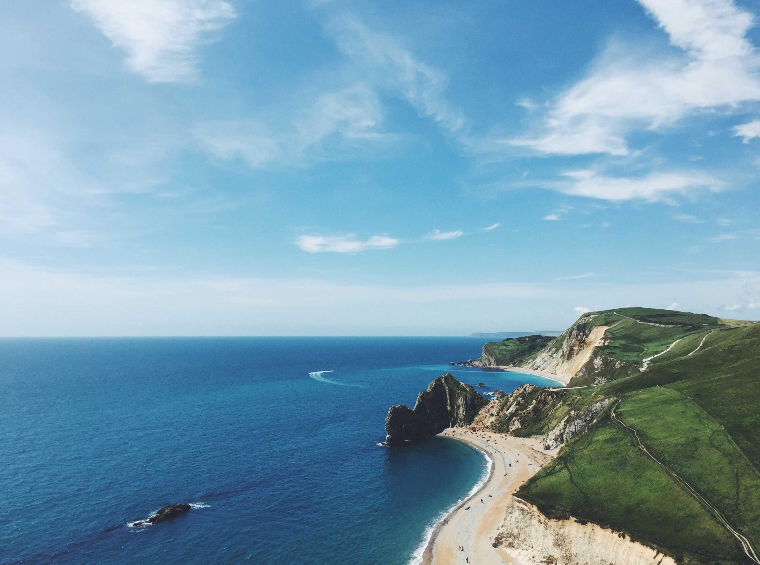 Aerial view of turquoise coastline with waves lapping the shore