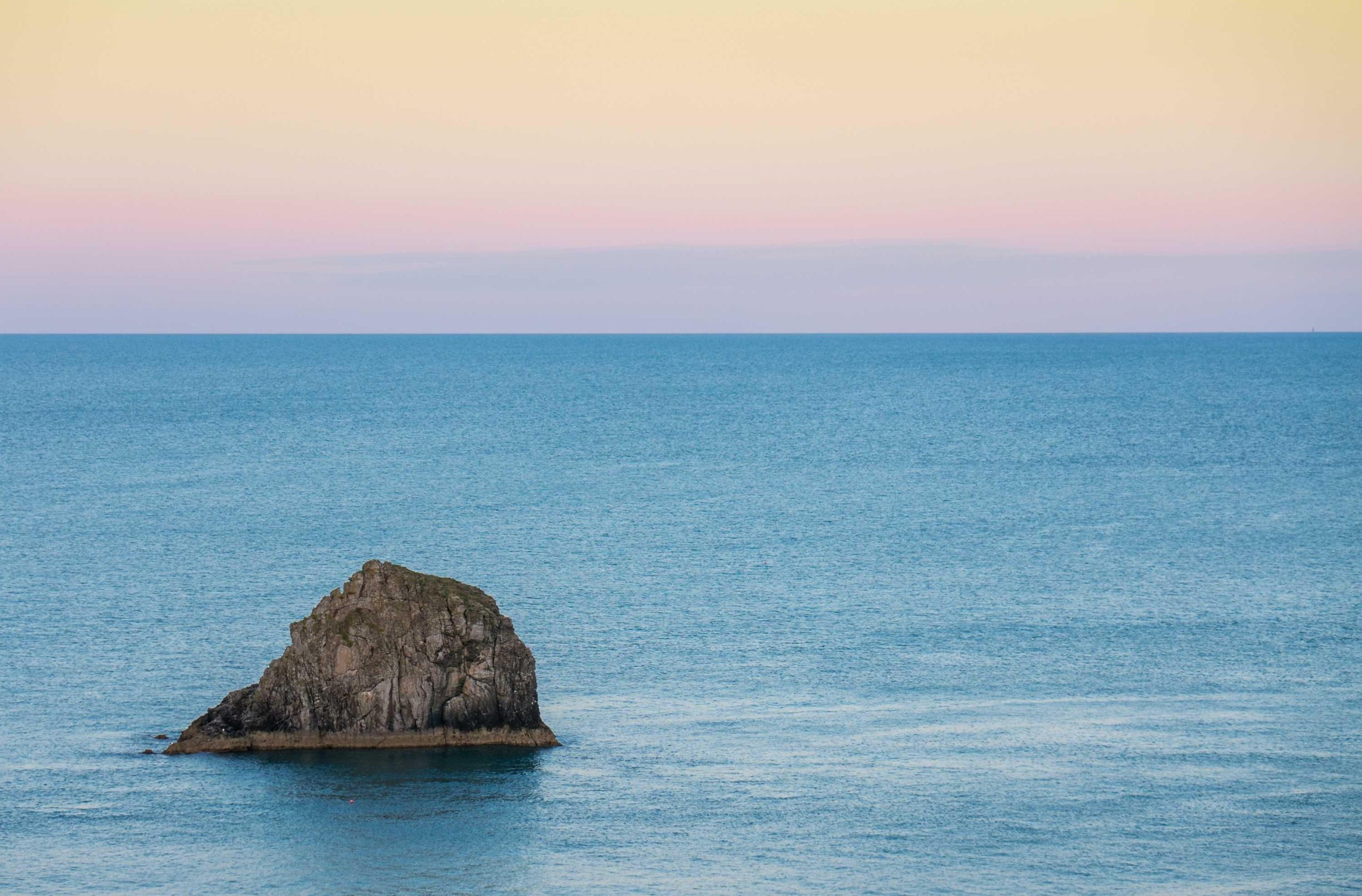 Vast blue sky stretching over open waters with soft clouds