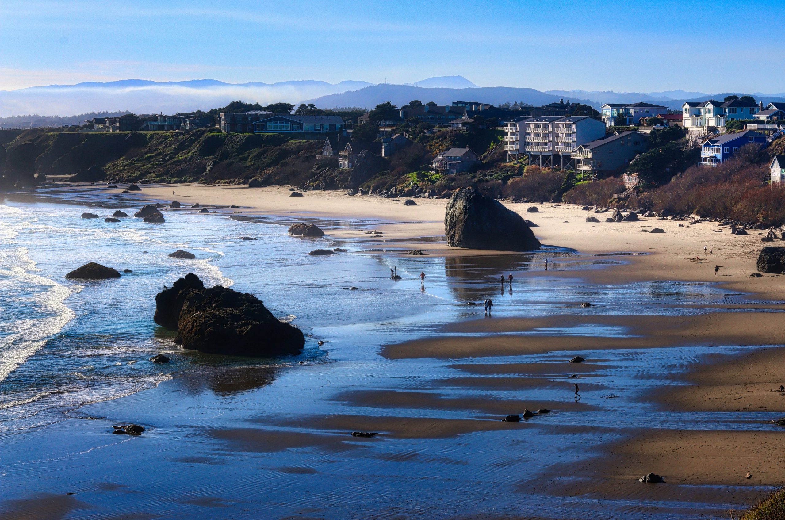 Coastal town on a sunny day with rocky beach.