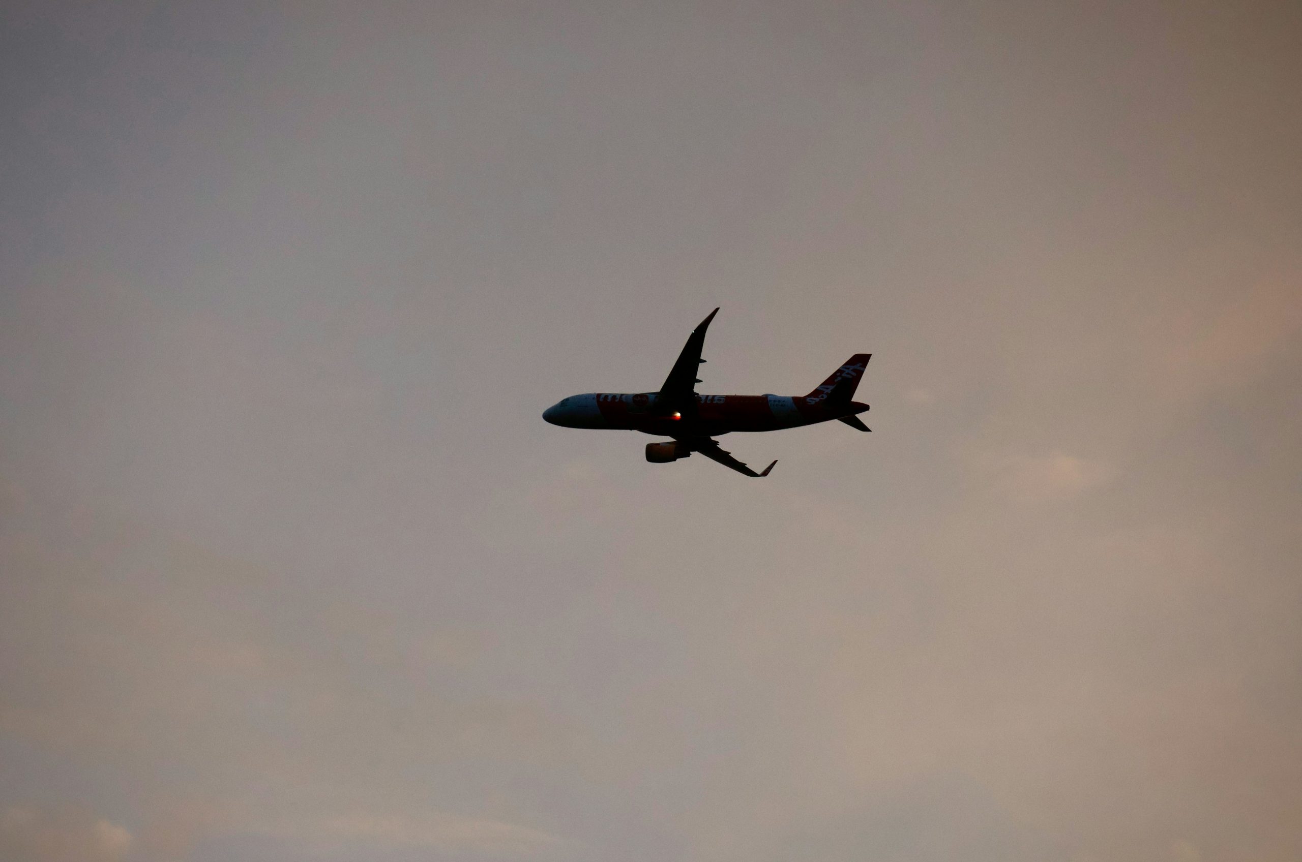 Airplane flying high in the cloudy sky