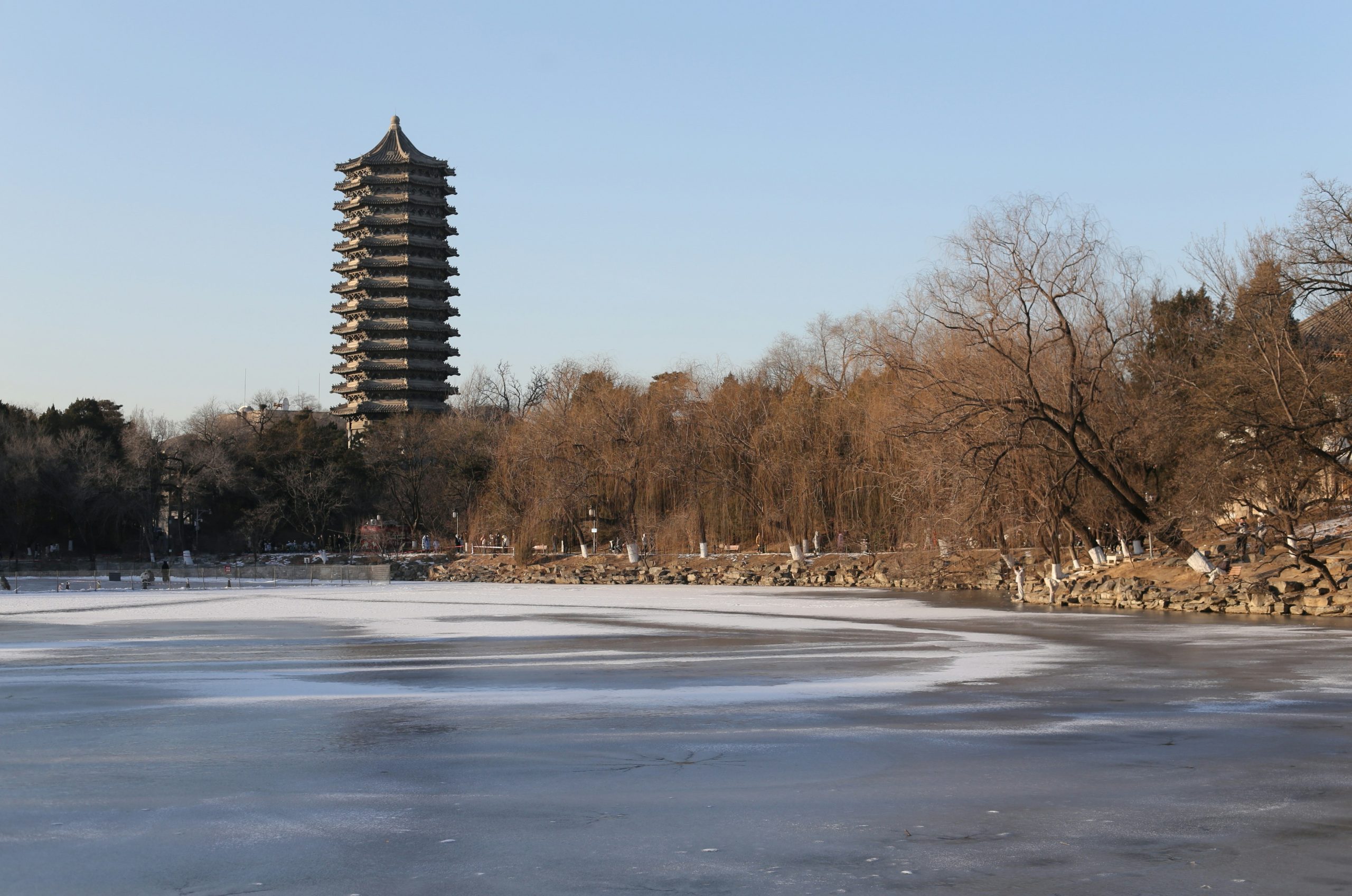Pagoda tower overlooking a frozen lake and bare trees
