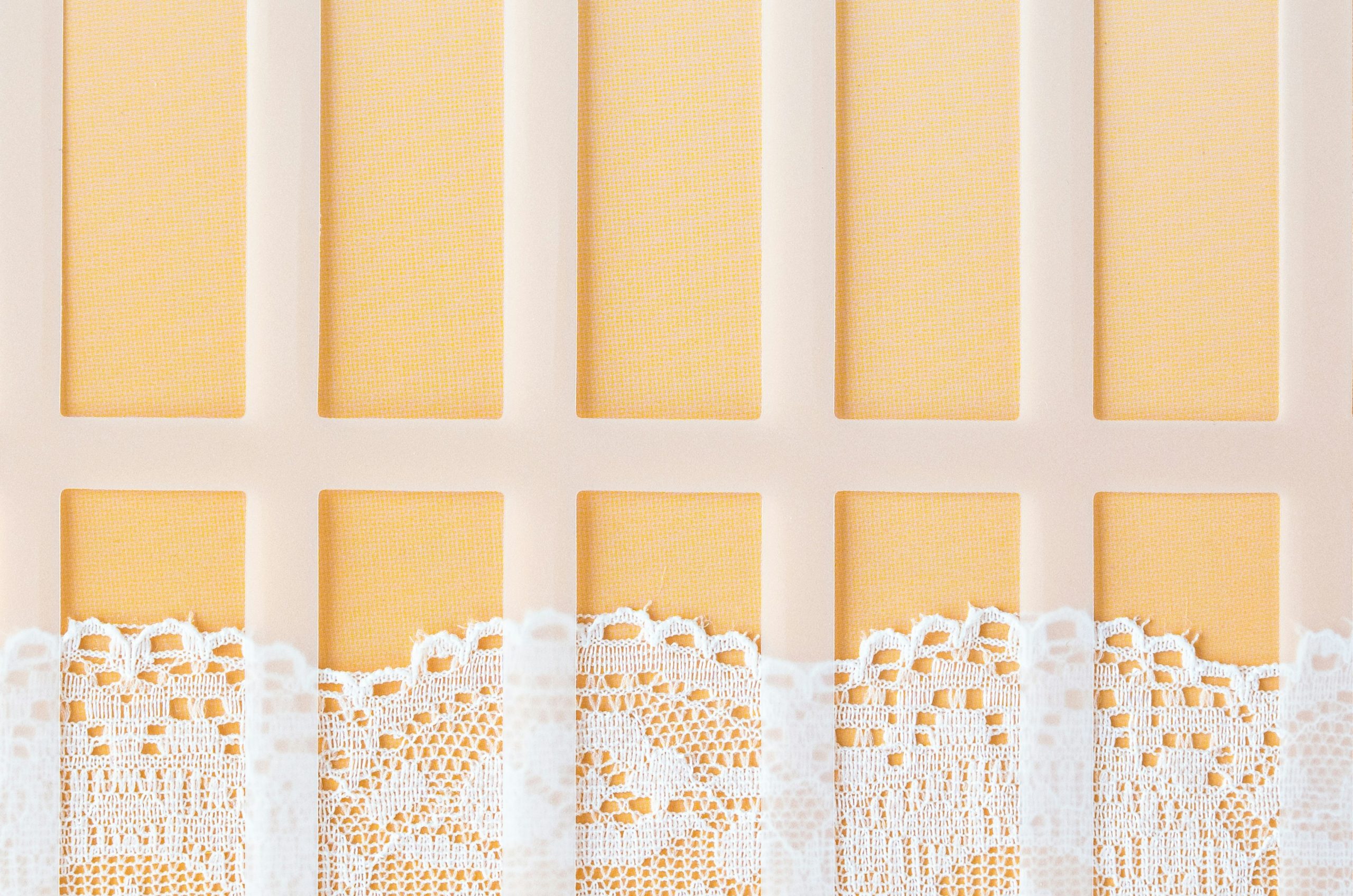 White lace trim against a pale peach background