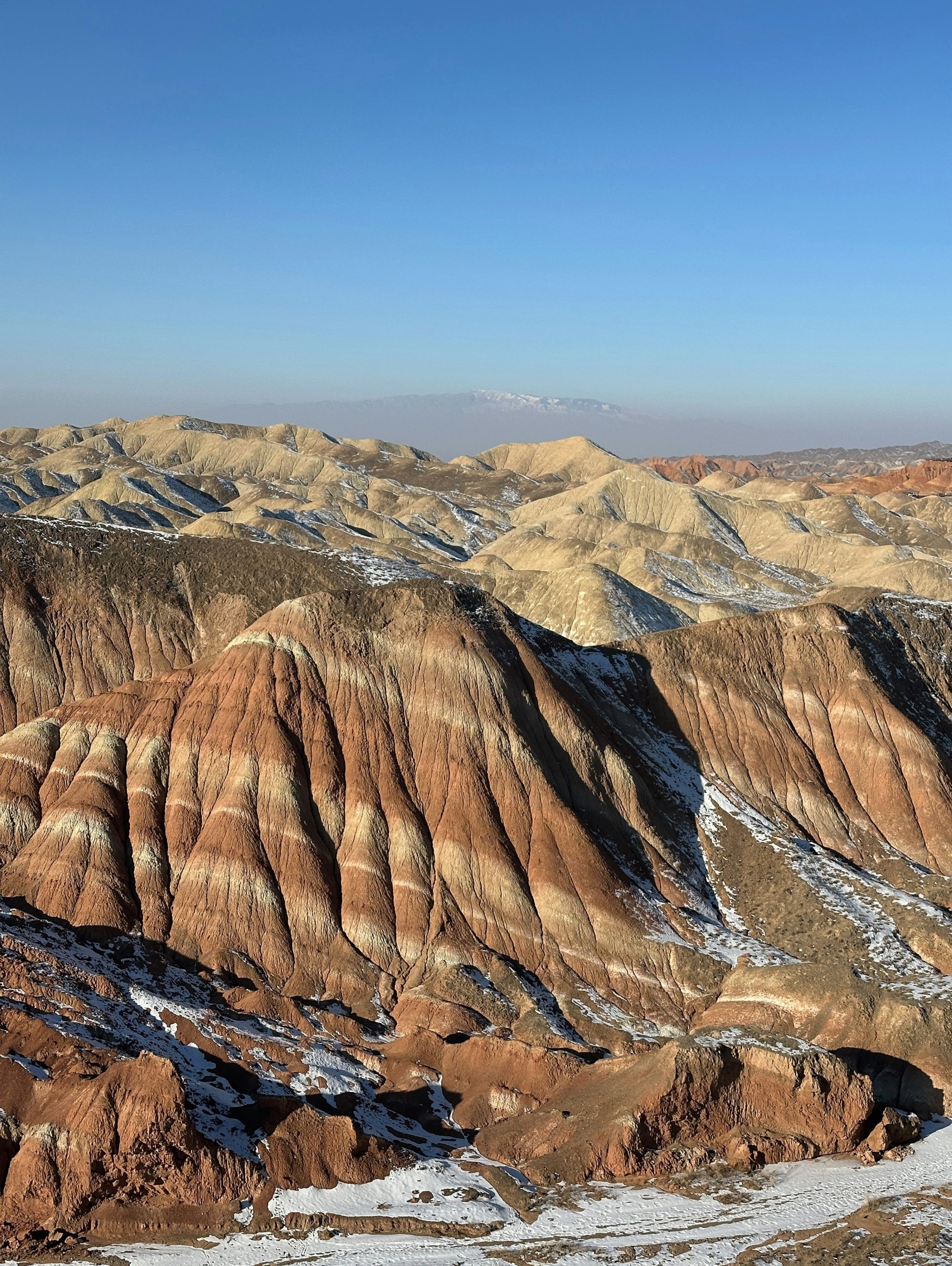 Colorful striped mountains under a clear blue sky