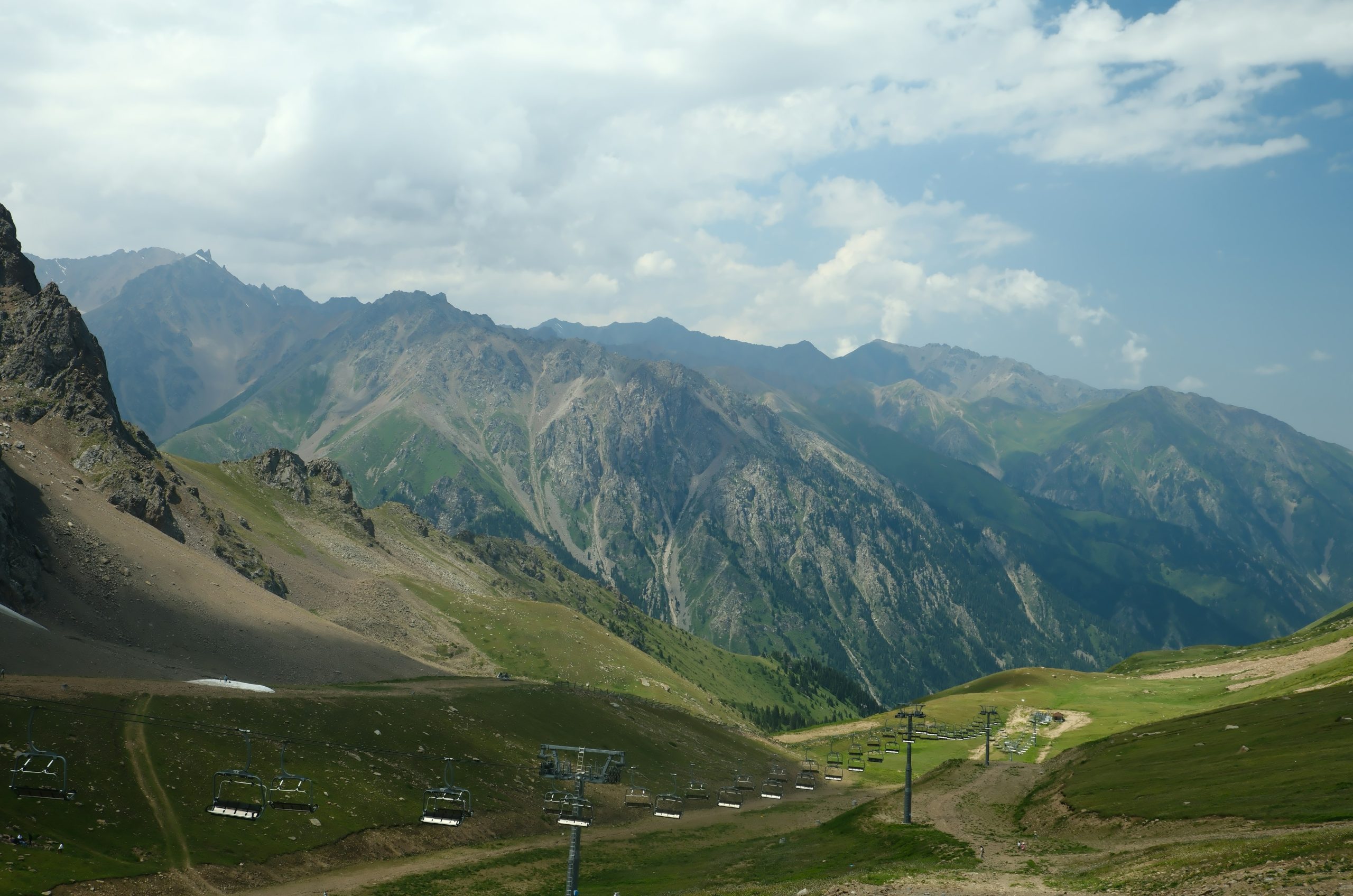 A scenic mountain landscape with green valleys and rocky peaks.