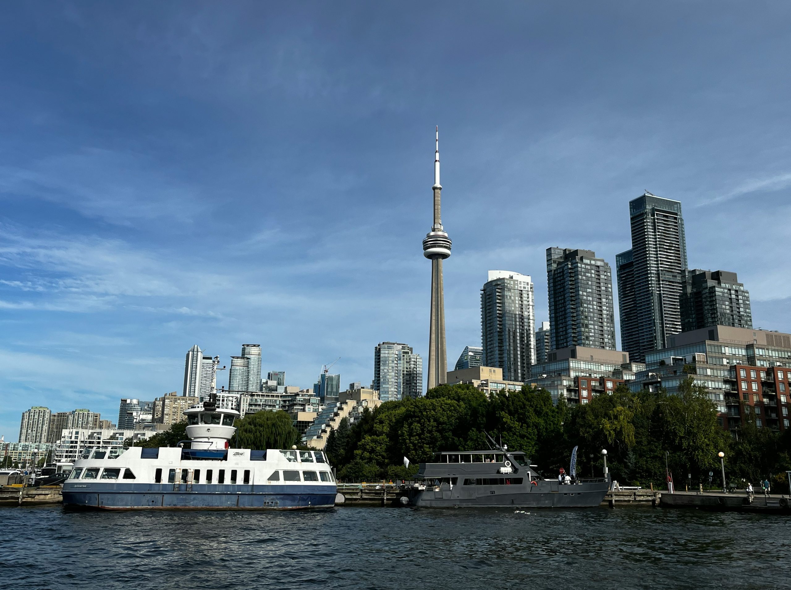 Toronto skyline with cn tower and ferries on water