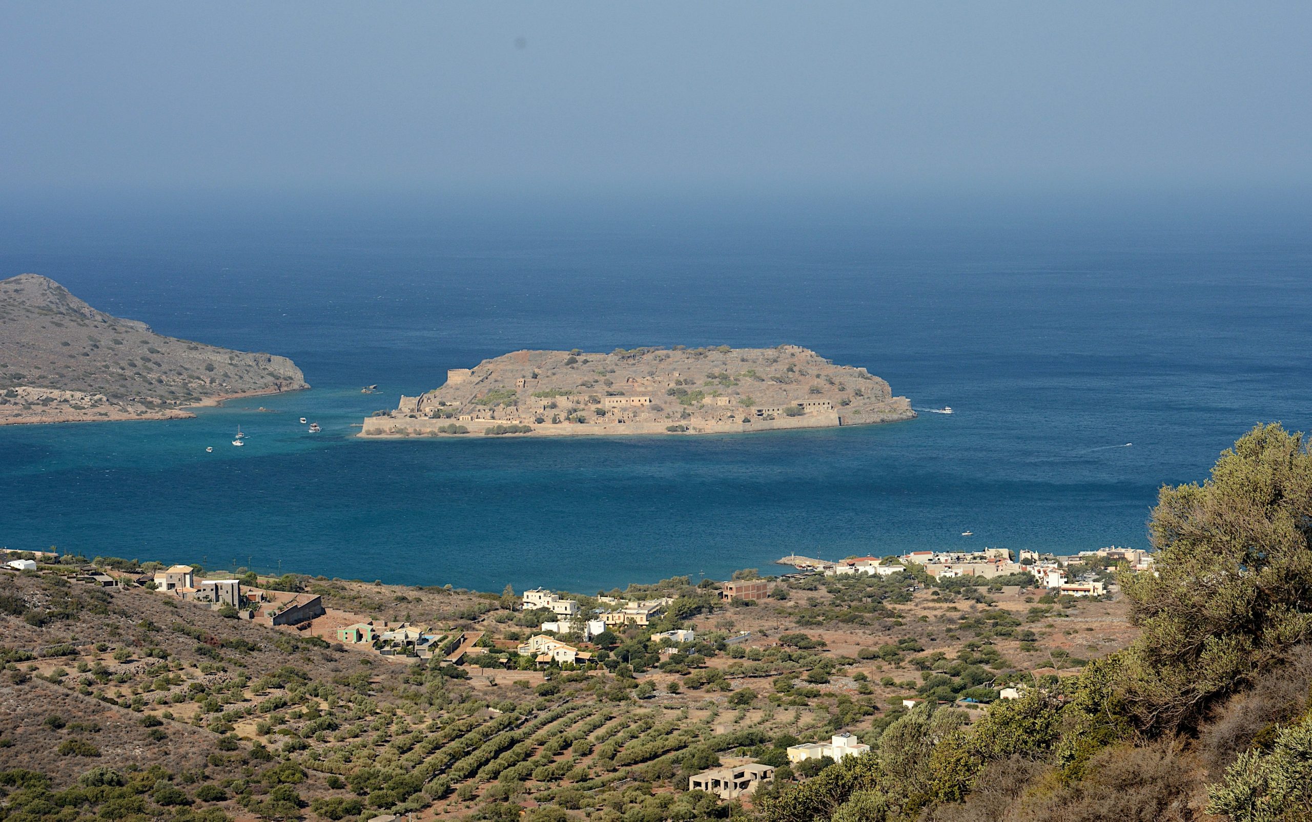 Island fortress in the blue sea with coastal village.