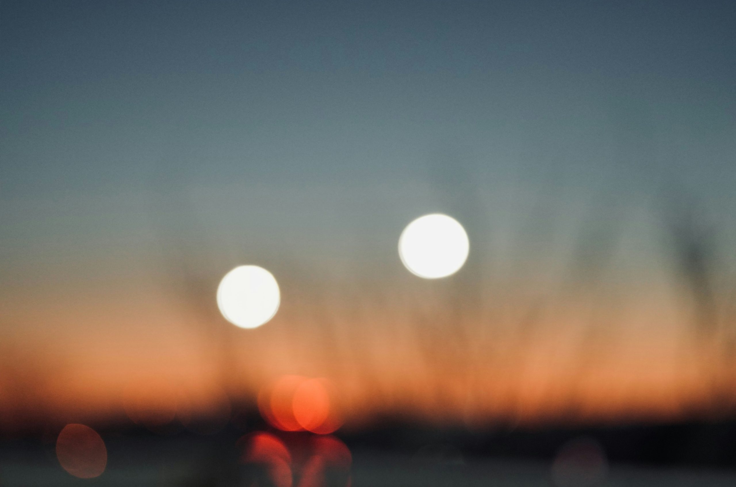 Blurred sunset with two bright orbs.