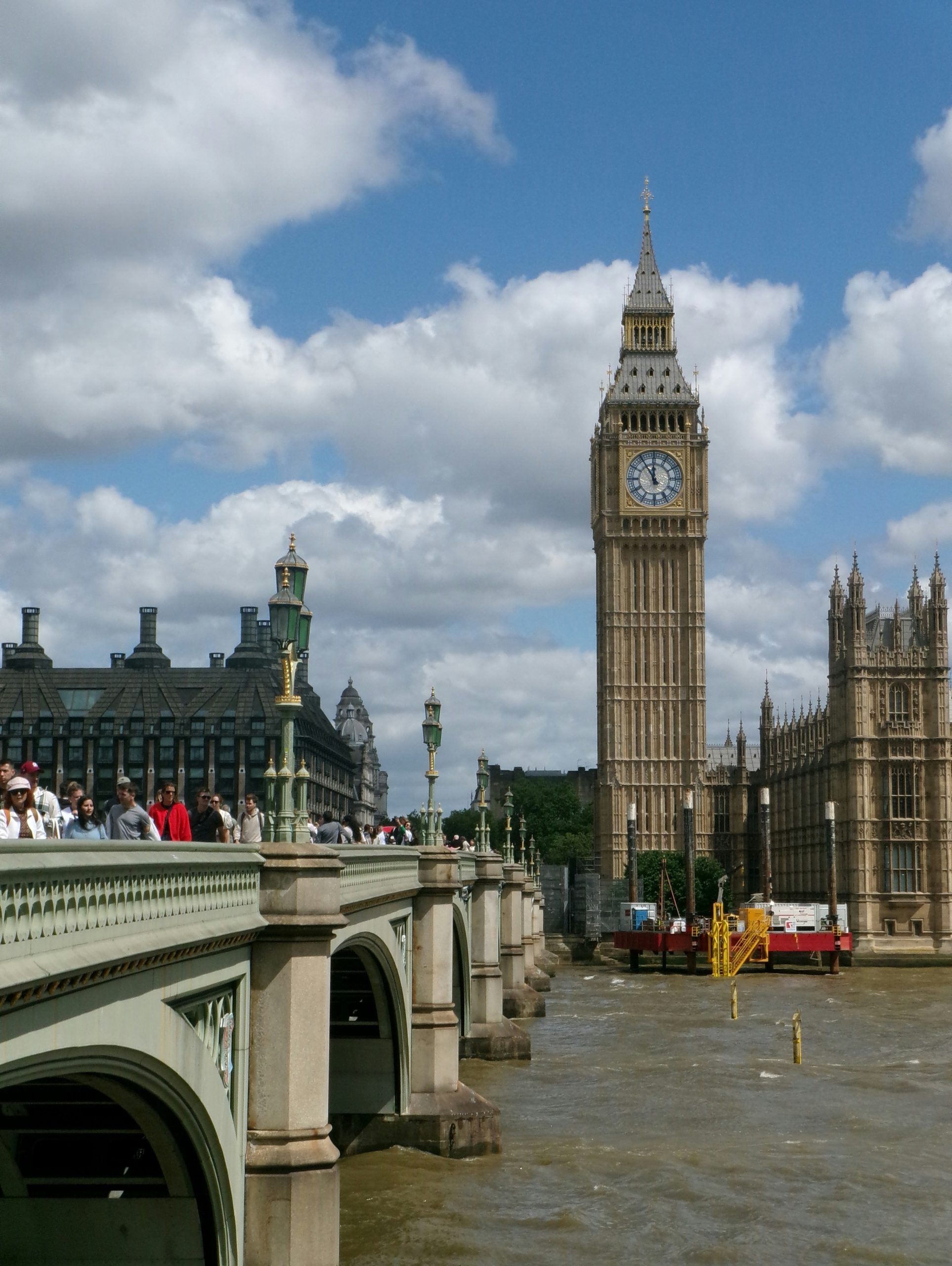 Big ben and westminster bridge under a cloudy sky.