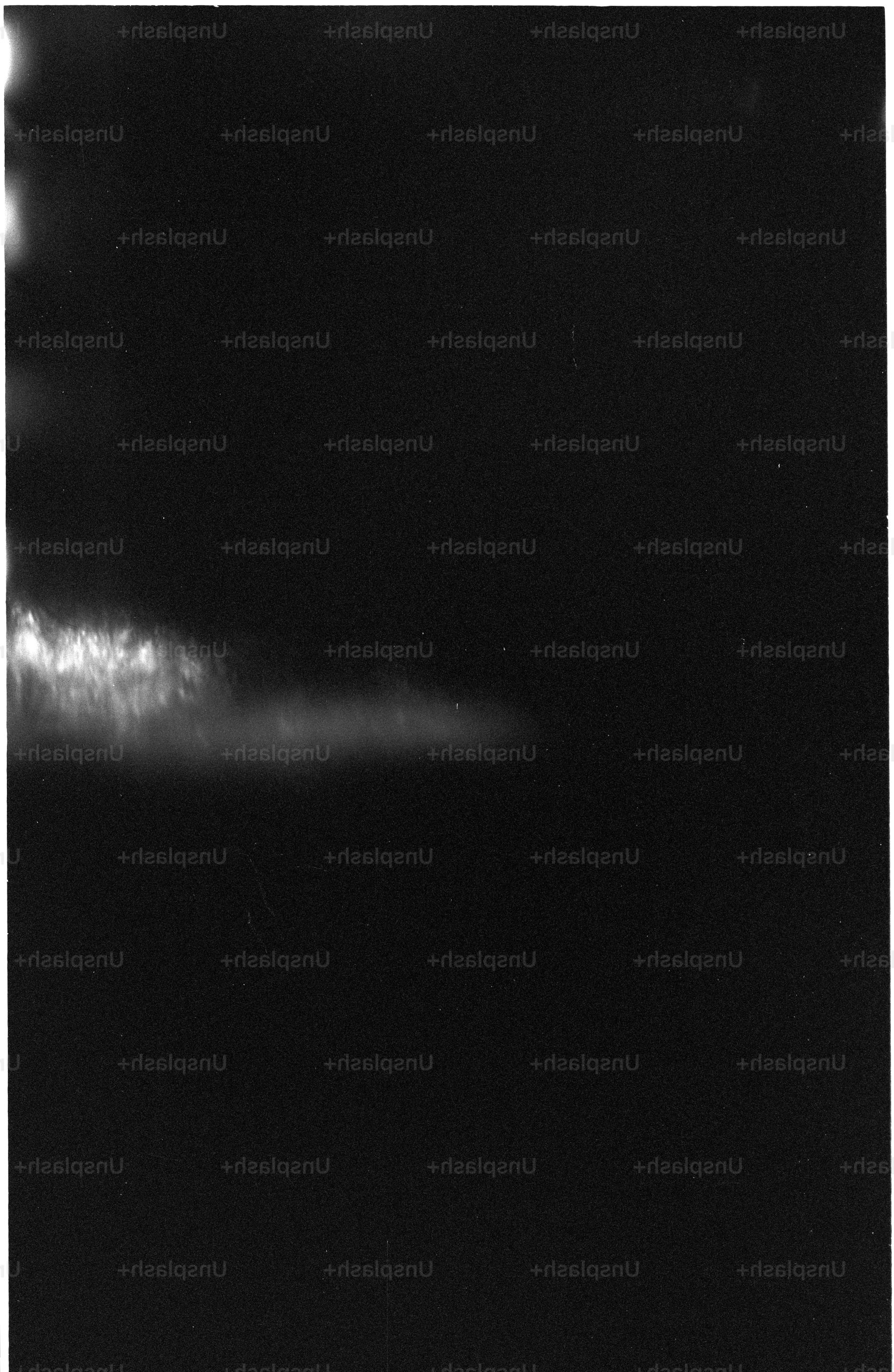 Dark sky with faint stars and a bright cloud formation.