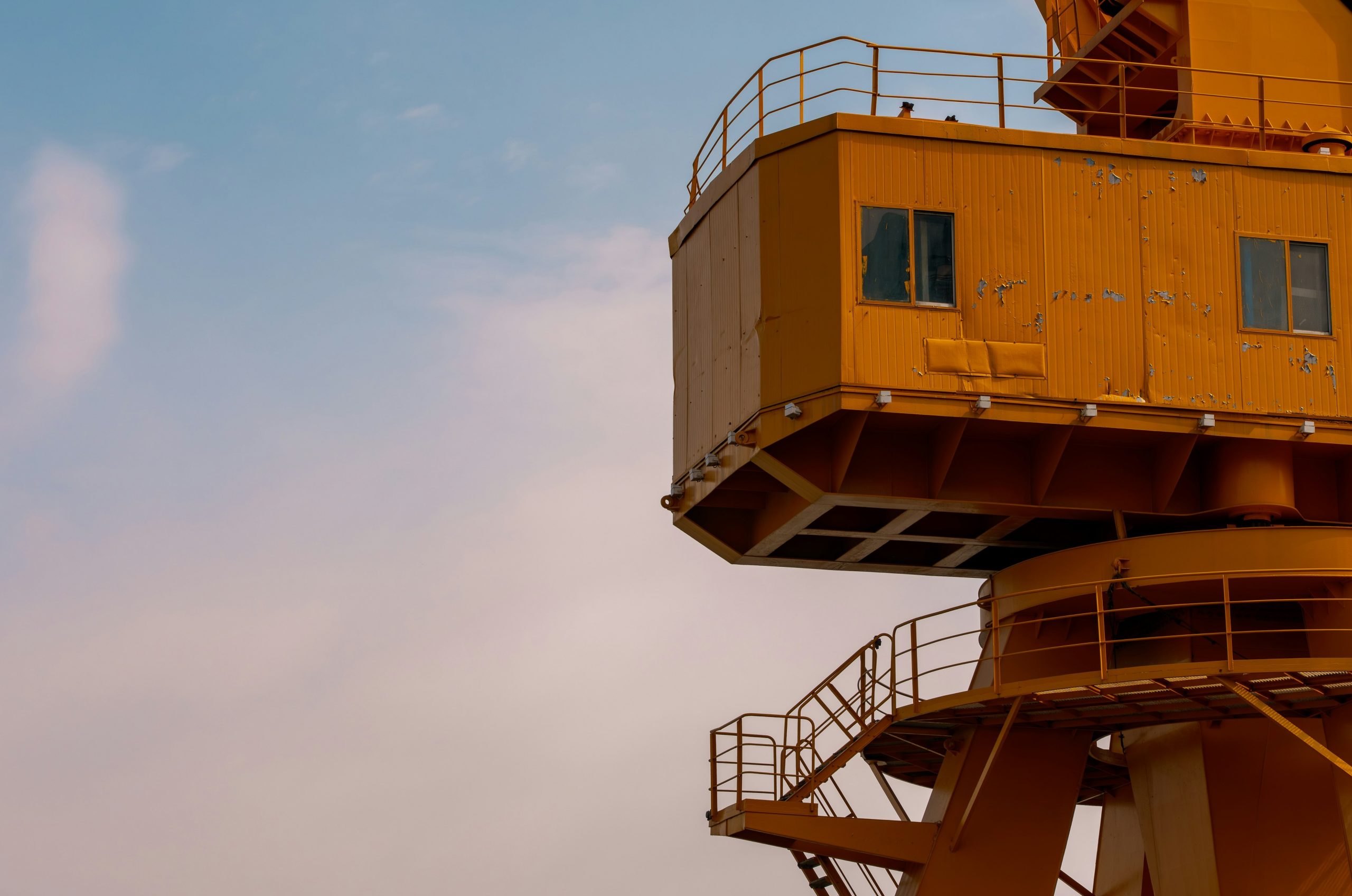 Yellow crane cabin against a cloudy sky