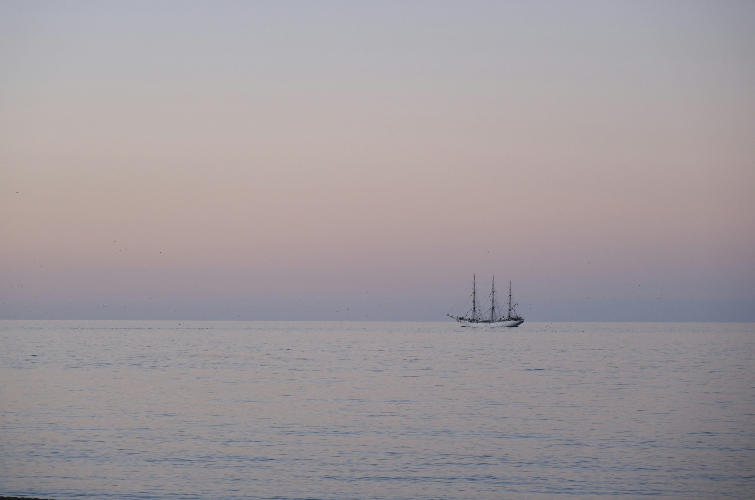 A sailboat on the ocean at dusk