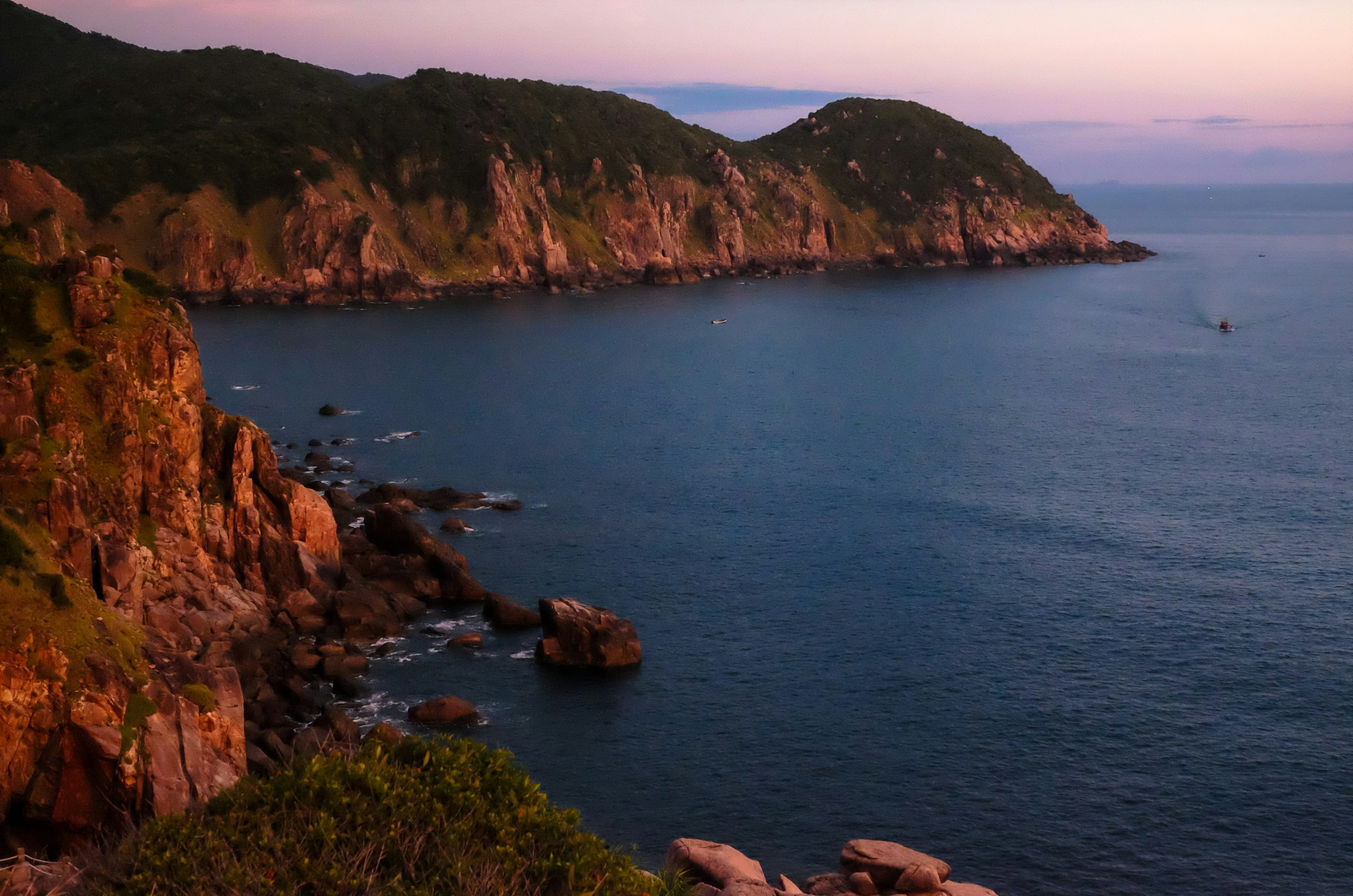 Rocky coastline with calm ocean at dusk