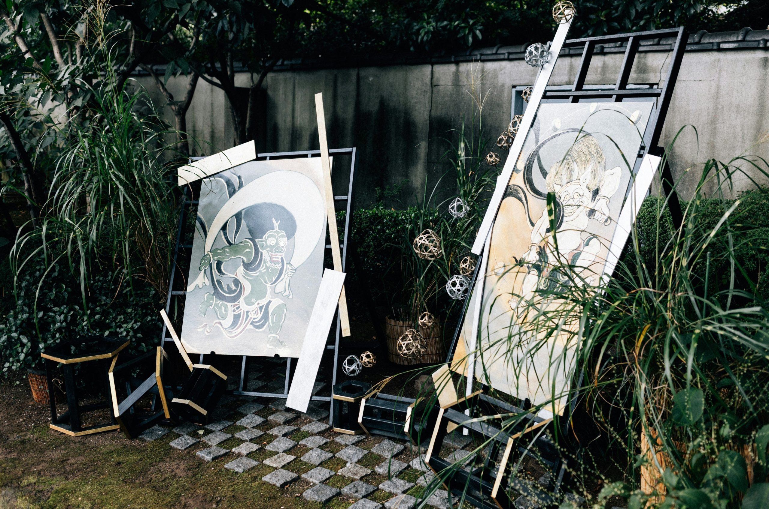 Two framed artworks leaning in a garden