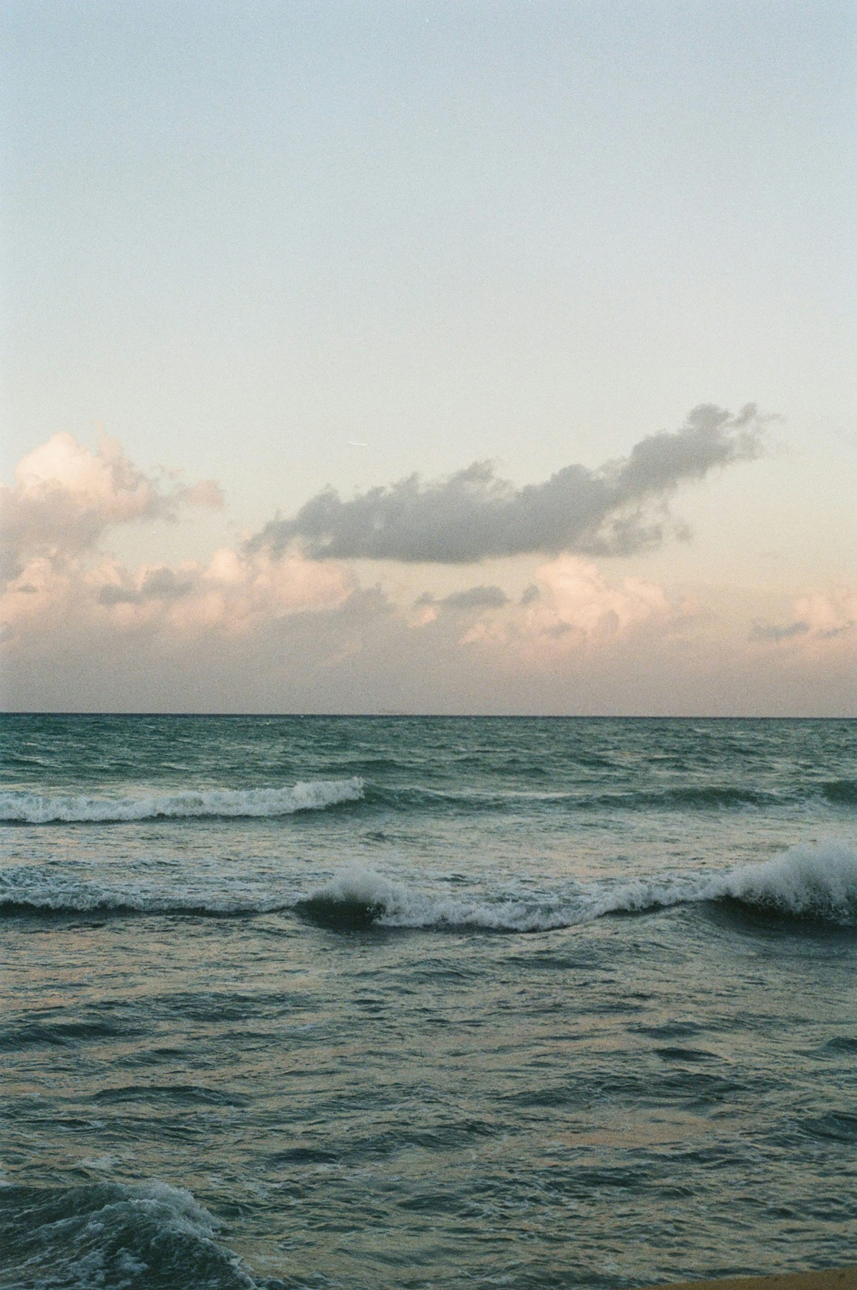 Waves gently lap the shore under a cloudy sky